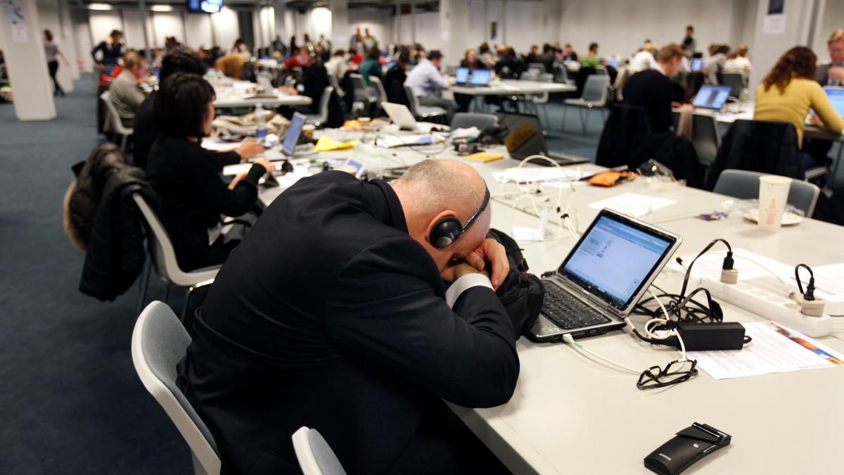 A journalist sleeps at the press centre of the UN summit on climate change (COP15), held at the Bella Centre in Copenhagen. DENMARK