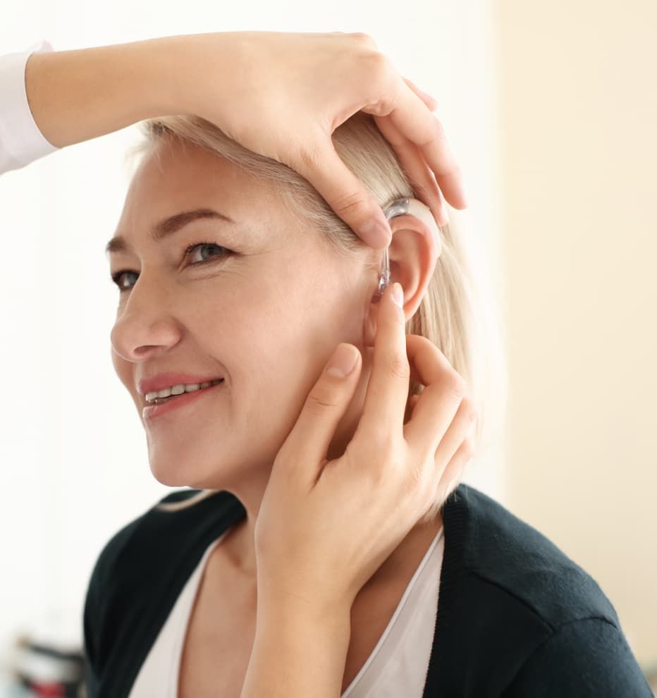 lady having a behind-the-ear hearing aid installed