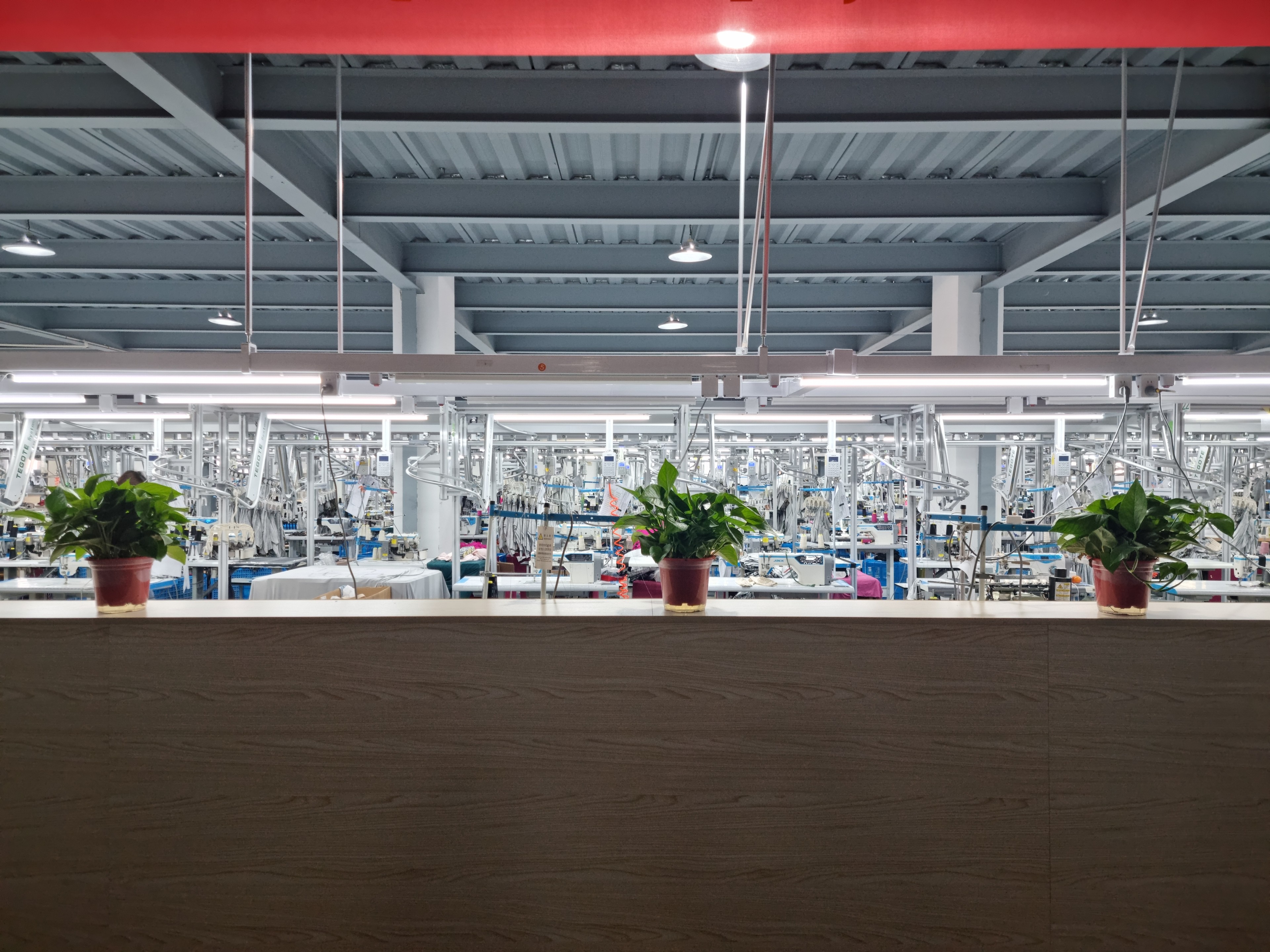 Production floor of a Bangladesh garment factory with rows of sewing machines and operators