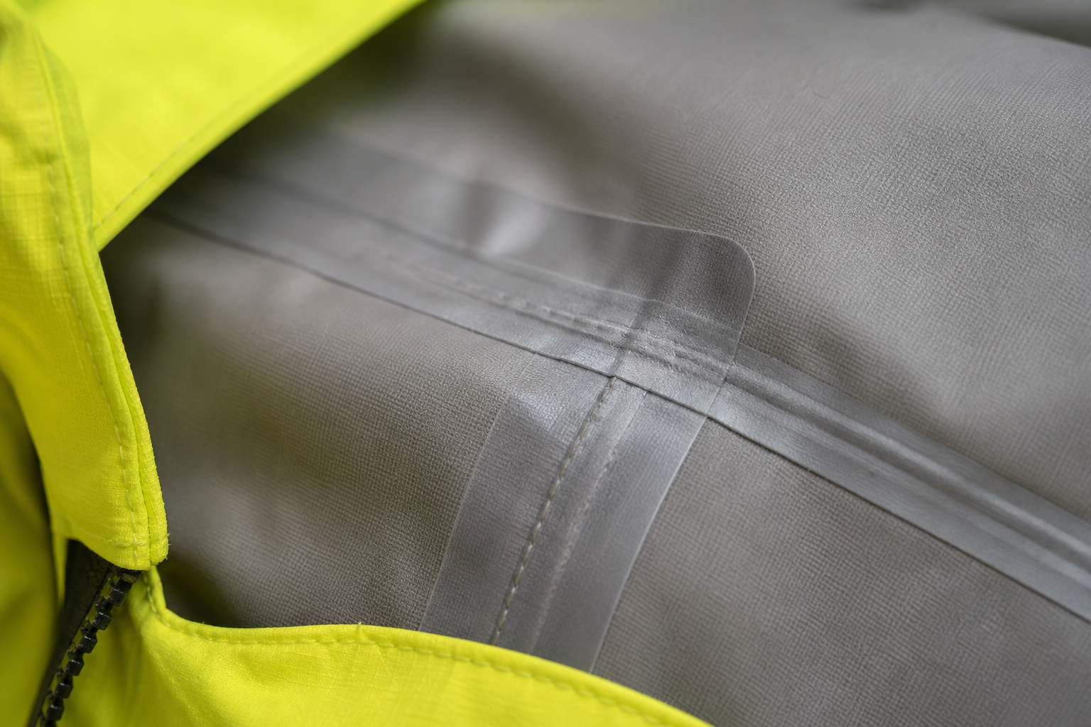 Seam tape applied over stitched seam on inside of waterproof workwear jacket