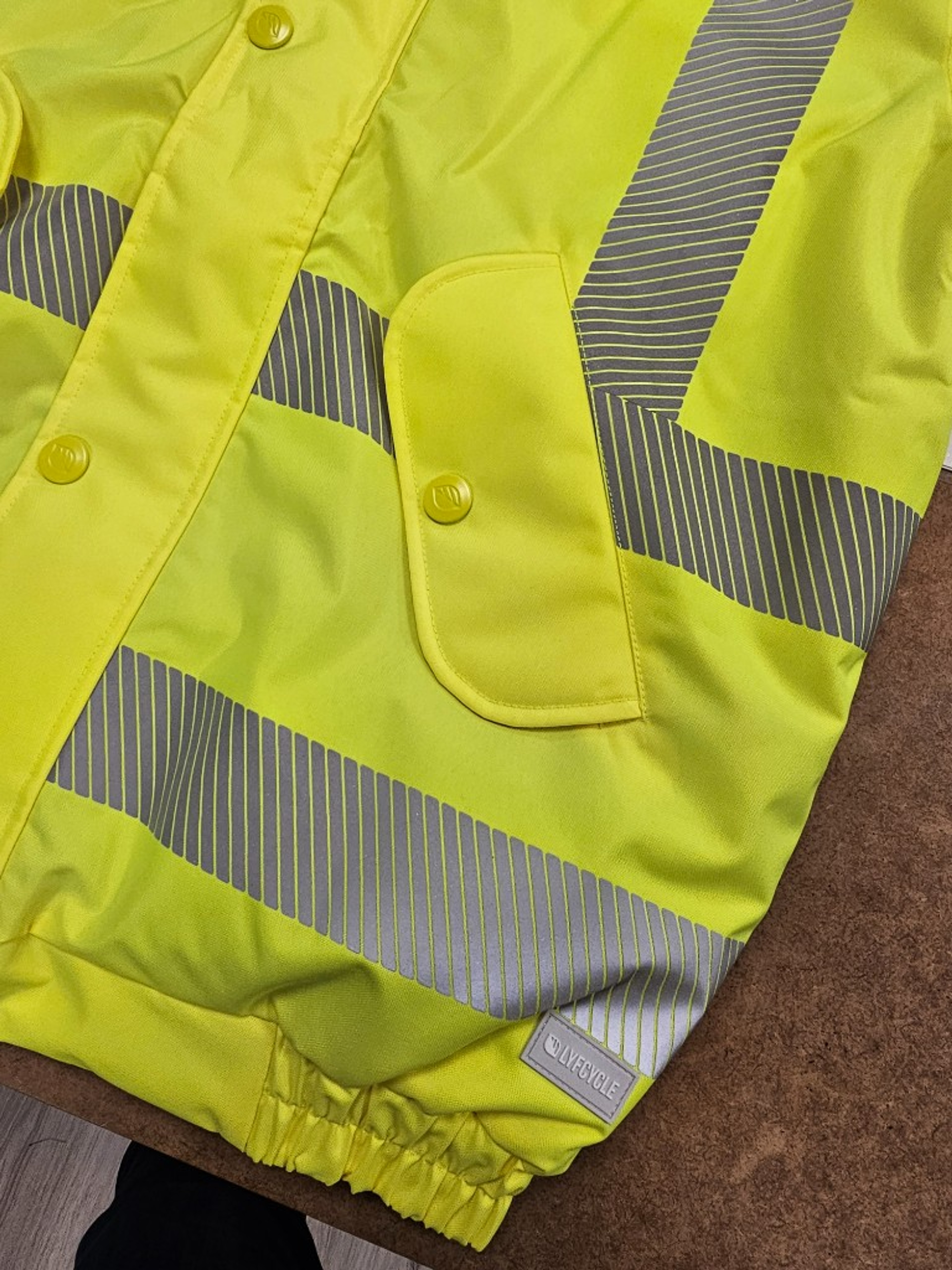 Two-tone hi-vis hooded safety jacket with reflective tape on a hanger