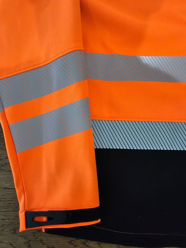 Hi-vis workwear sleeve showing segmented retroreflective tape application conforming to EN ISO 20471 design rules