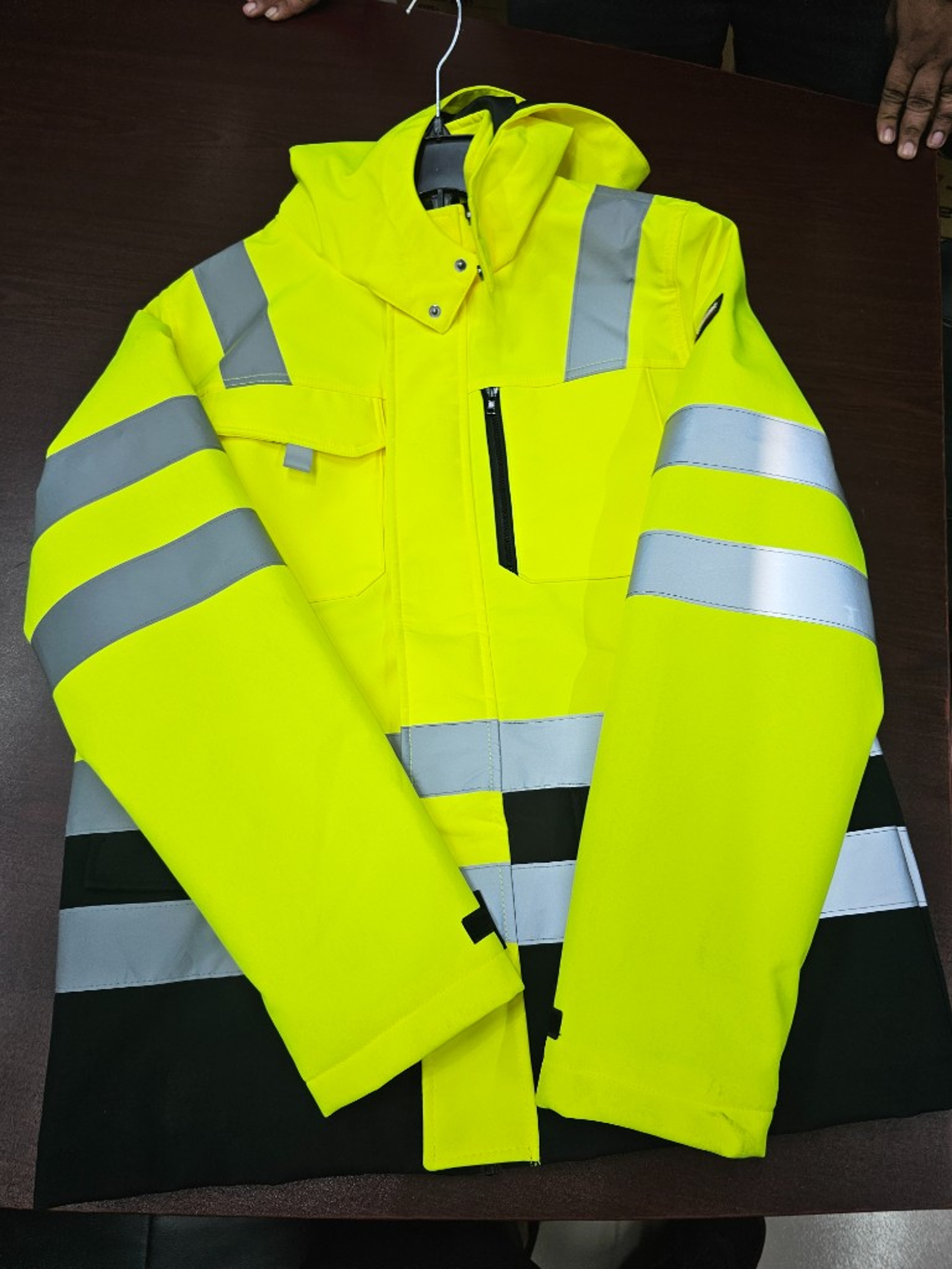 Two-tone hi-vis insulated safety jacket laid flat showing retroreflective tape layout and fluorescent panels