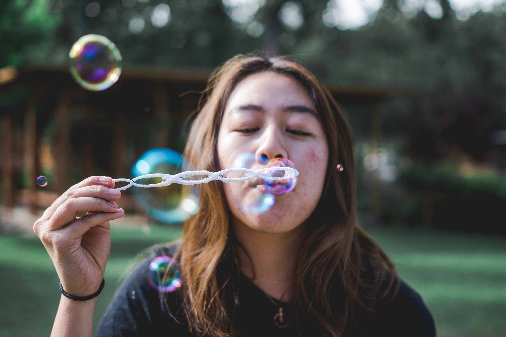 A LYF counselor blowing bubbles through a bubble wand