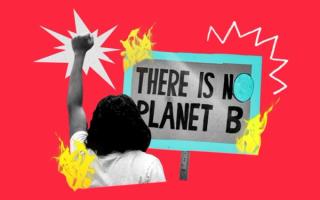 person protesting holding their fist in the air in front of a sign reading 'there is no planet b'