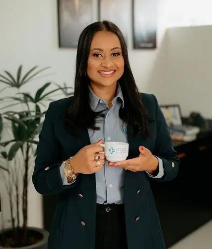 Mulher sorrindo segurando caneca da Mais Contábil em escritório