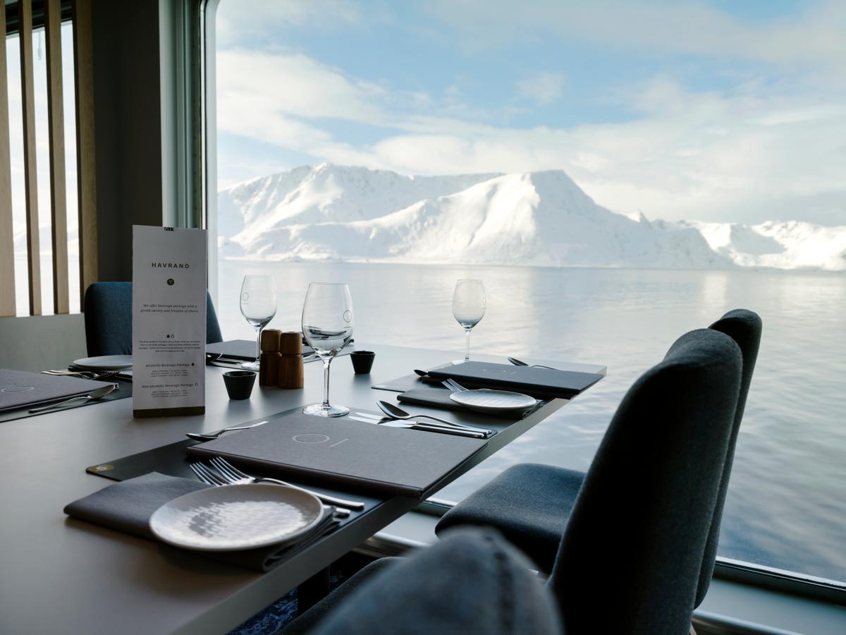 Gedeckter Tisch im Restaurant Havrand an einem Fenster mit Blick auf schneebedeckte Berge