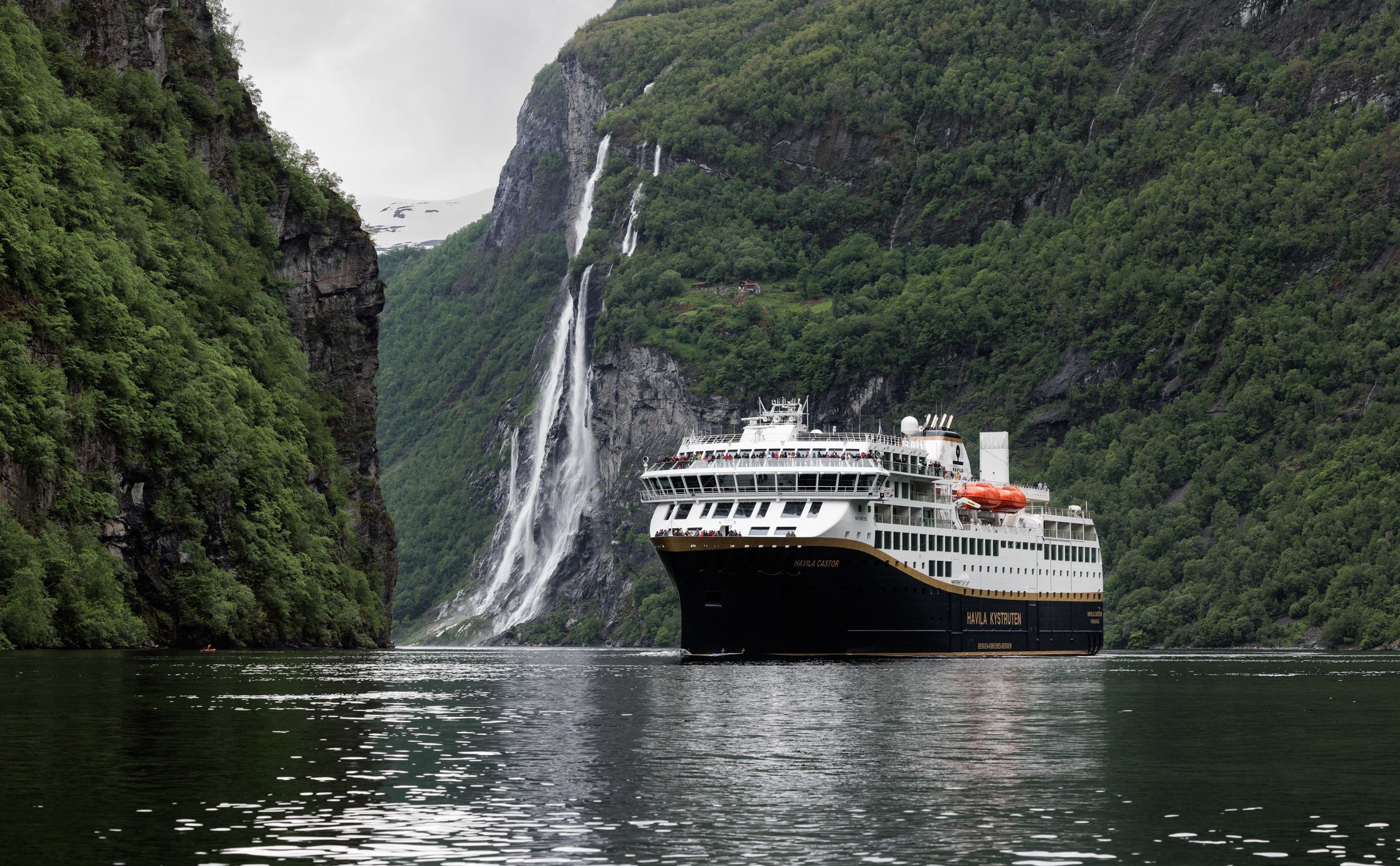 Kreuzfahrt auf dem Geirangerfjord zu einem von steilen Bergen umgebenen Wasserfall