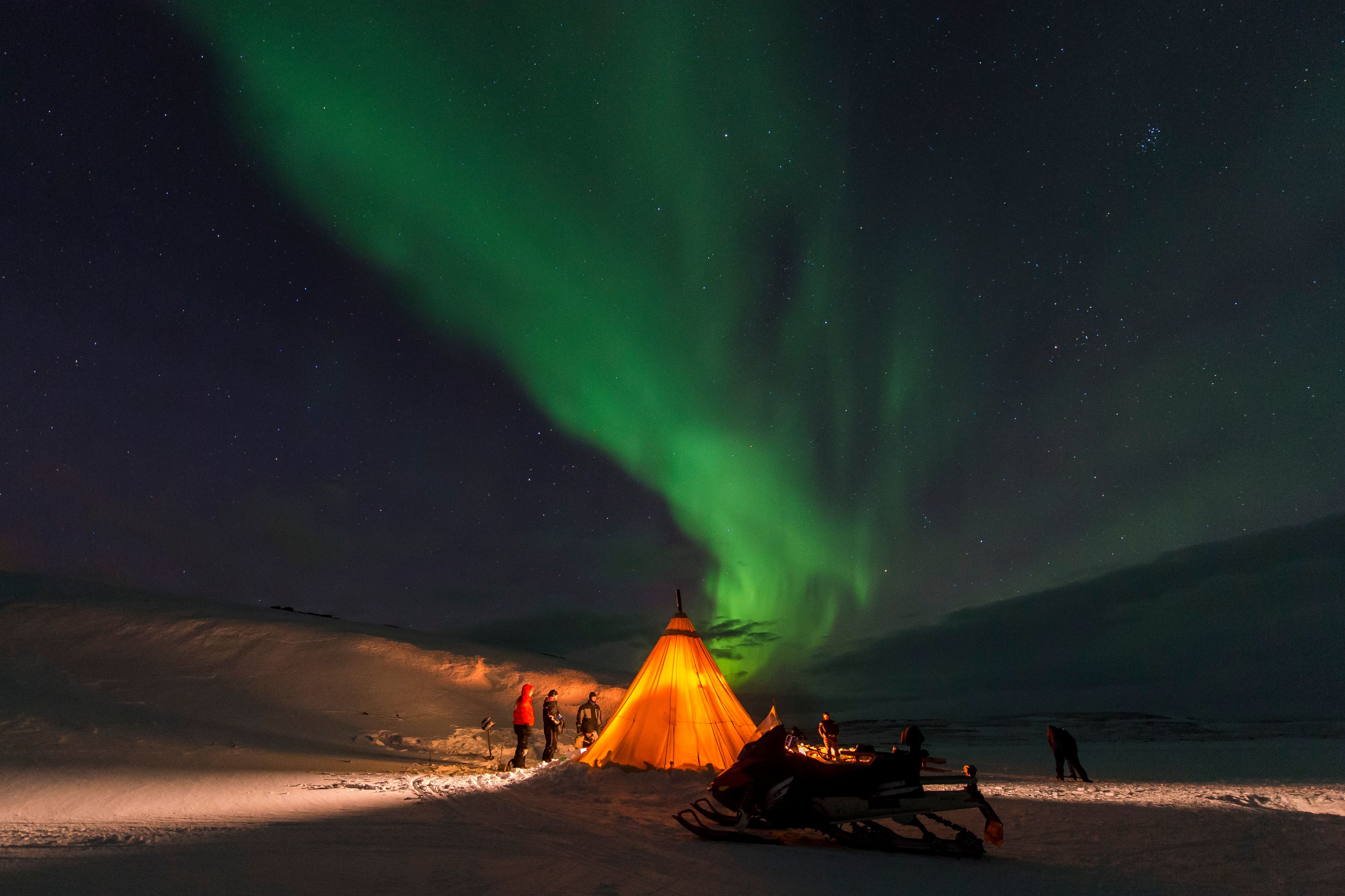Group of snow mobile drivers in the polar night