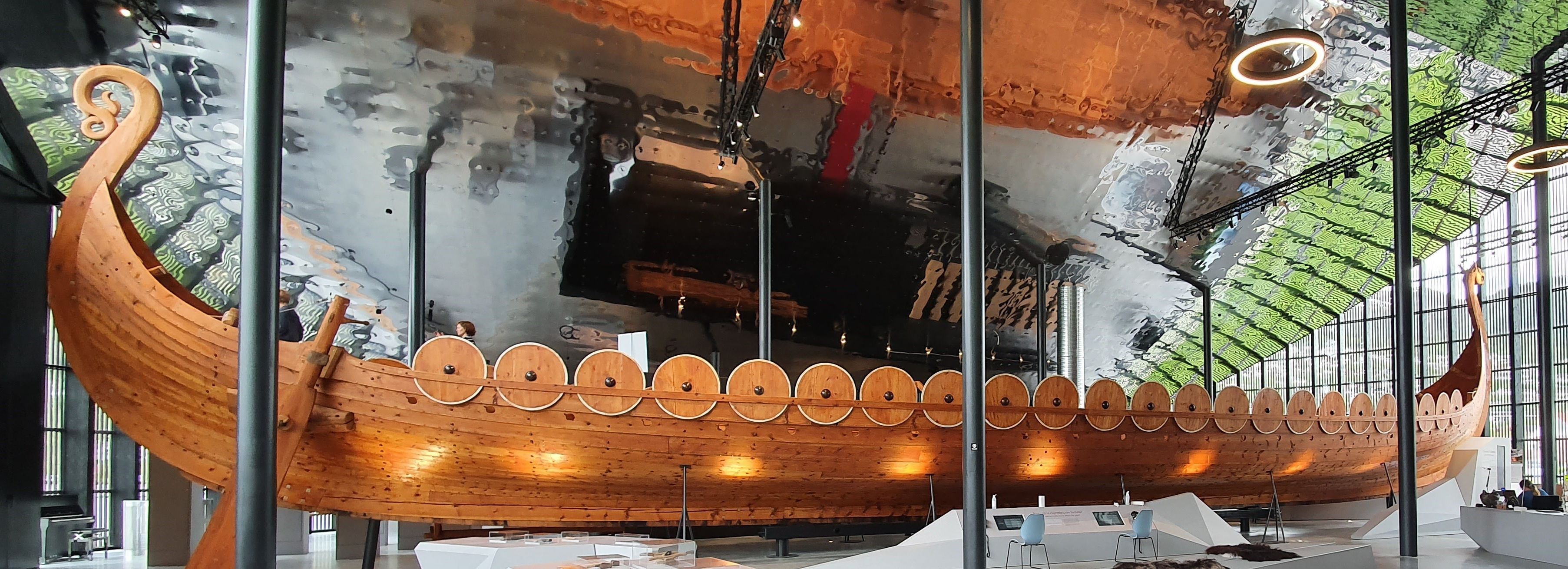 Ein traditionelles Wikingerschiff, das in einem Innenraum ausgestellt ist und die maritime Handwerkskunst der Nordmänner zeigt