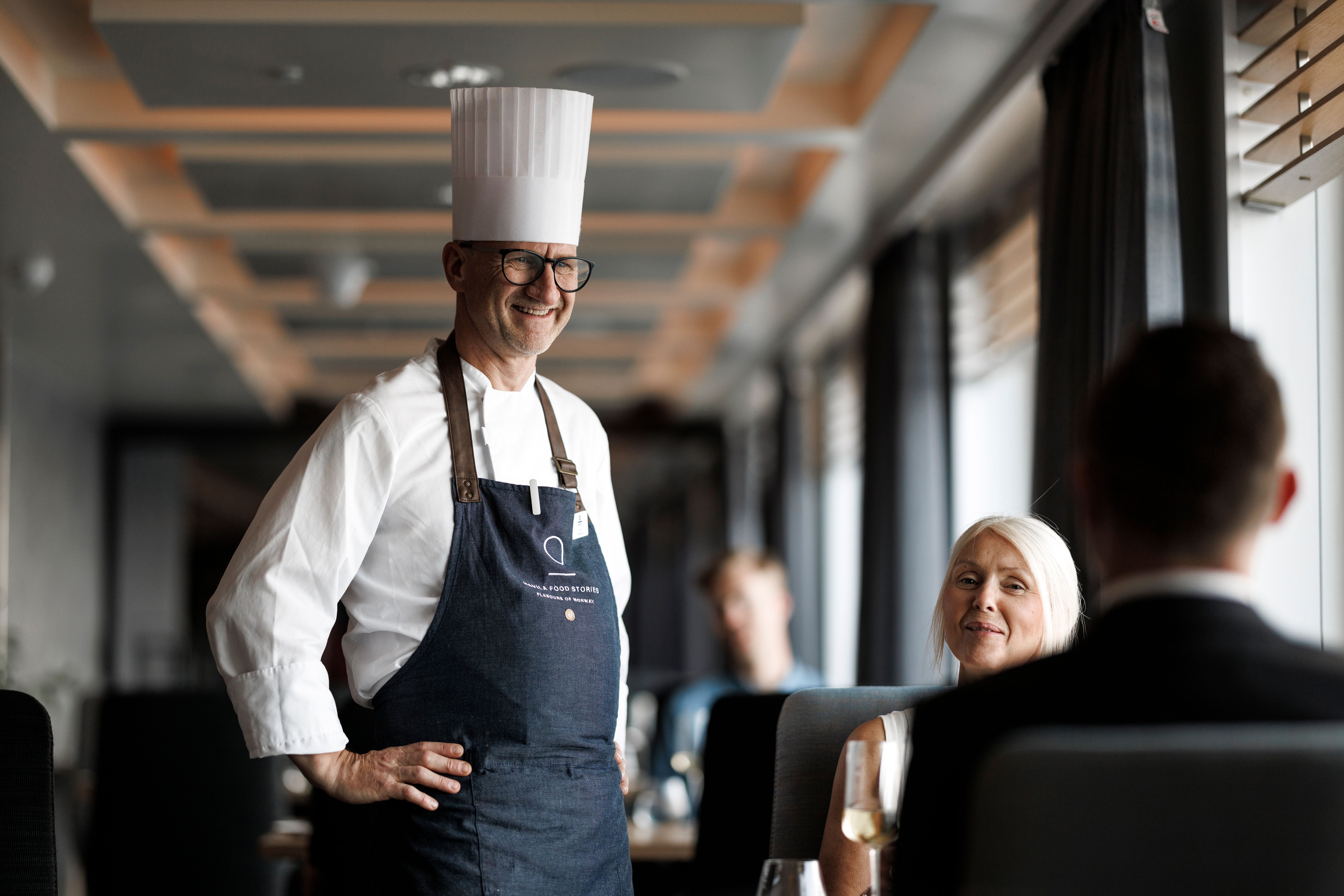 Koch im Gespräch mit Gästen im Restaurant