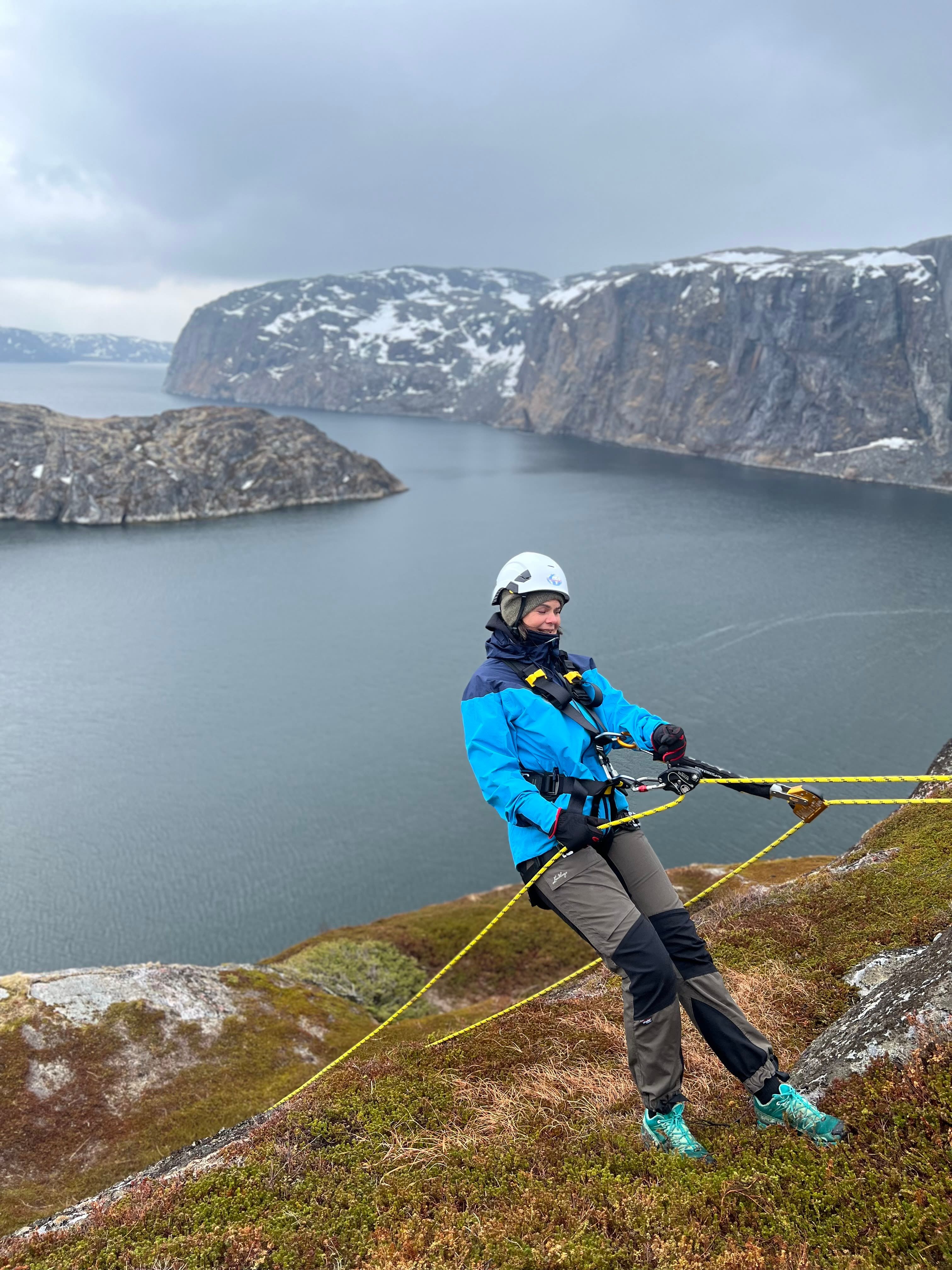 Participant preparing to rappel down a sea cliff during the Arctic Rappelling Route in Northern Norway.
