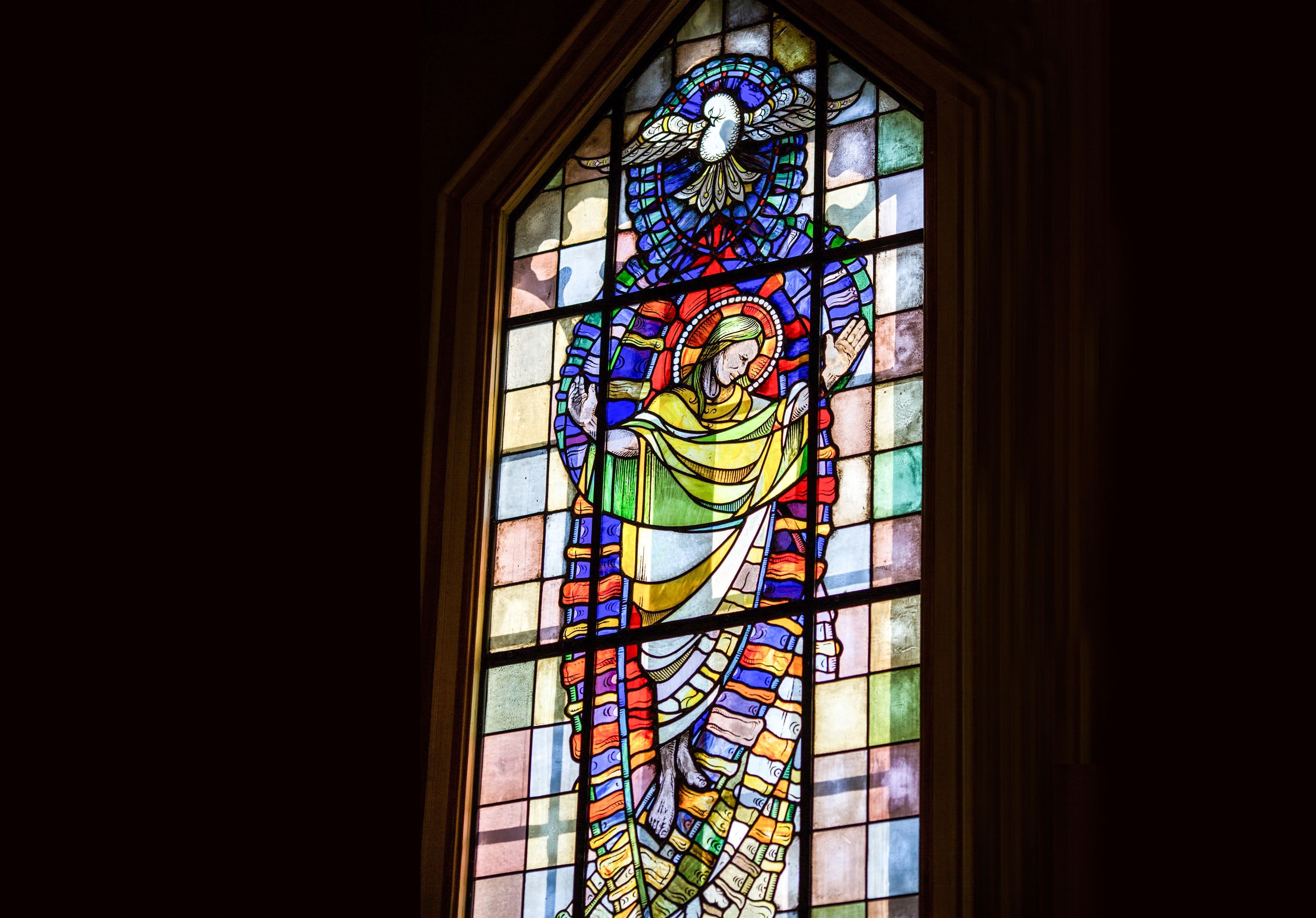 Detailansicht eines bemalten Kirchenfensters im Innenraum