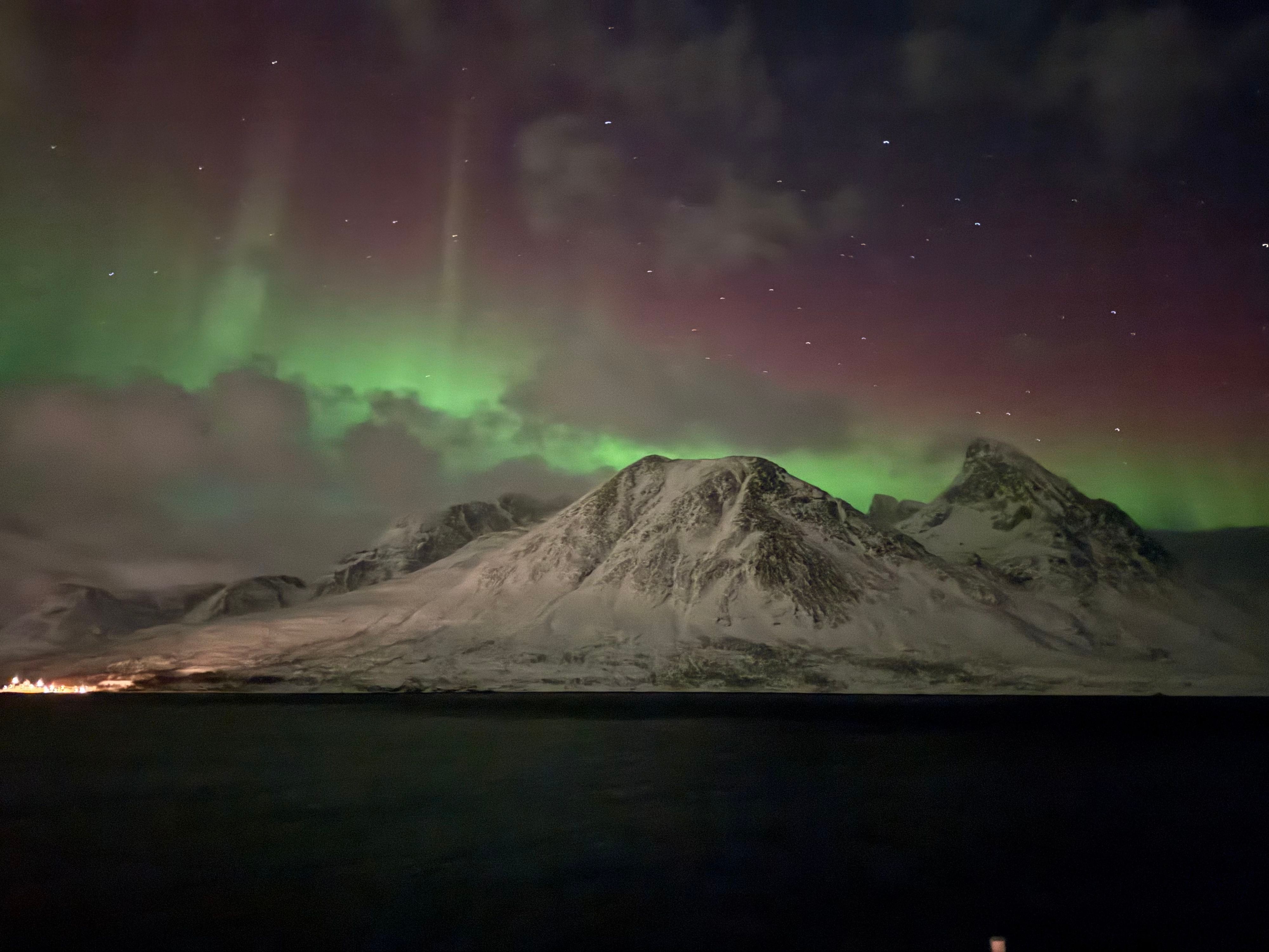 Bunte Nordlichter, gesehen von einem Havila-Schiff, das entlang der norwegischen Küste fährt.