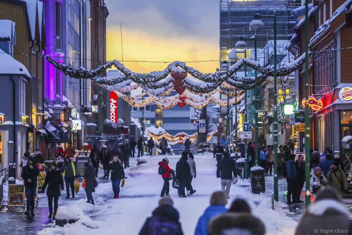 Snødekt handlegate i Tromsø pyntet med festlige julelys og juledekorasjoner.