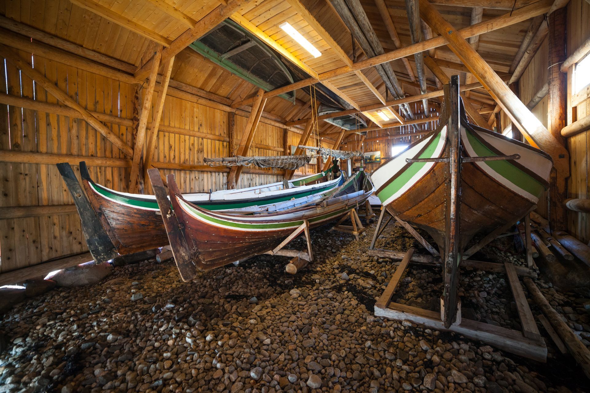 Traditional wooden Nordland fishing boats on display inside a historic timber boathouse in Lofoten, Norway