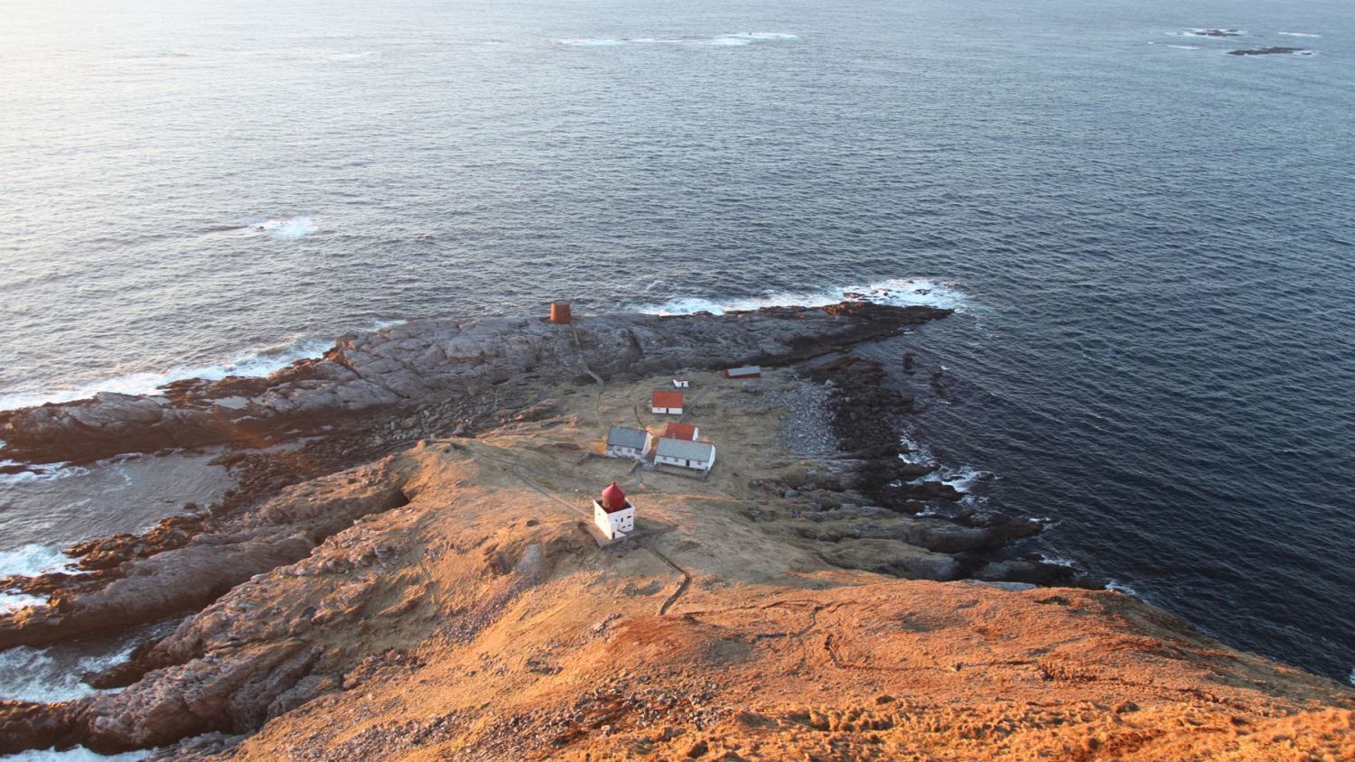 Runde Lighthouse on Runde Island, Norway, overlooking the rugged Atlantic coastline, dramatic cliffs, and the rich seabird habitats of Norway's west coast