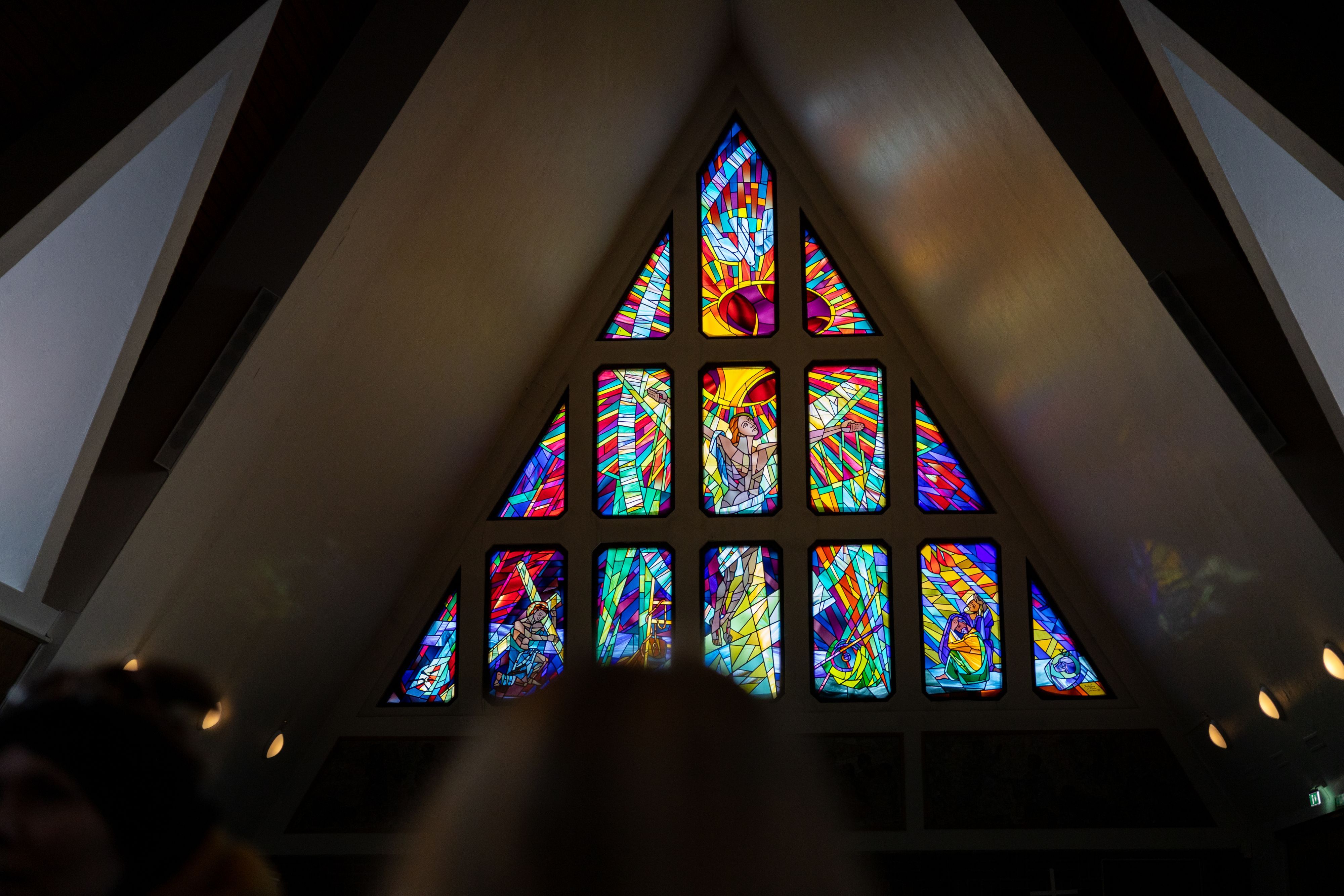Fargerikt glassmaleri som viser religiøse motiver inne i Hammerfest kirke på en byvandring, Norge