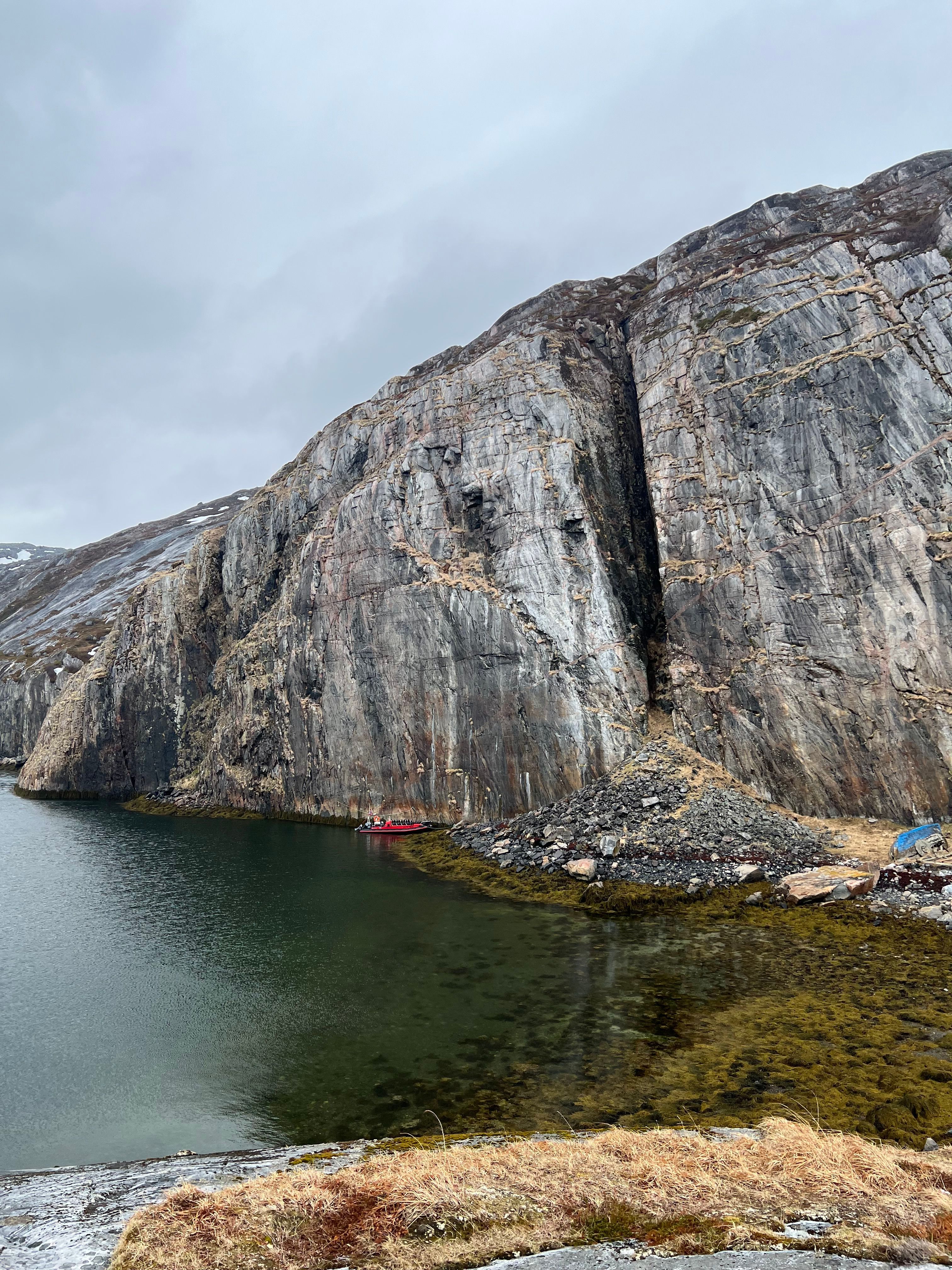 Towering sea cliff rising directly from the Arctic fjord, the dramatic location of the Arctic Rappelling Route in Northern Norway.