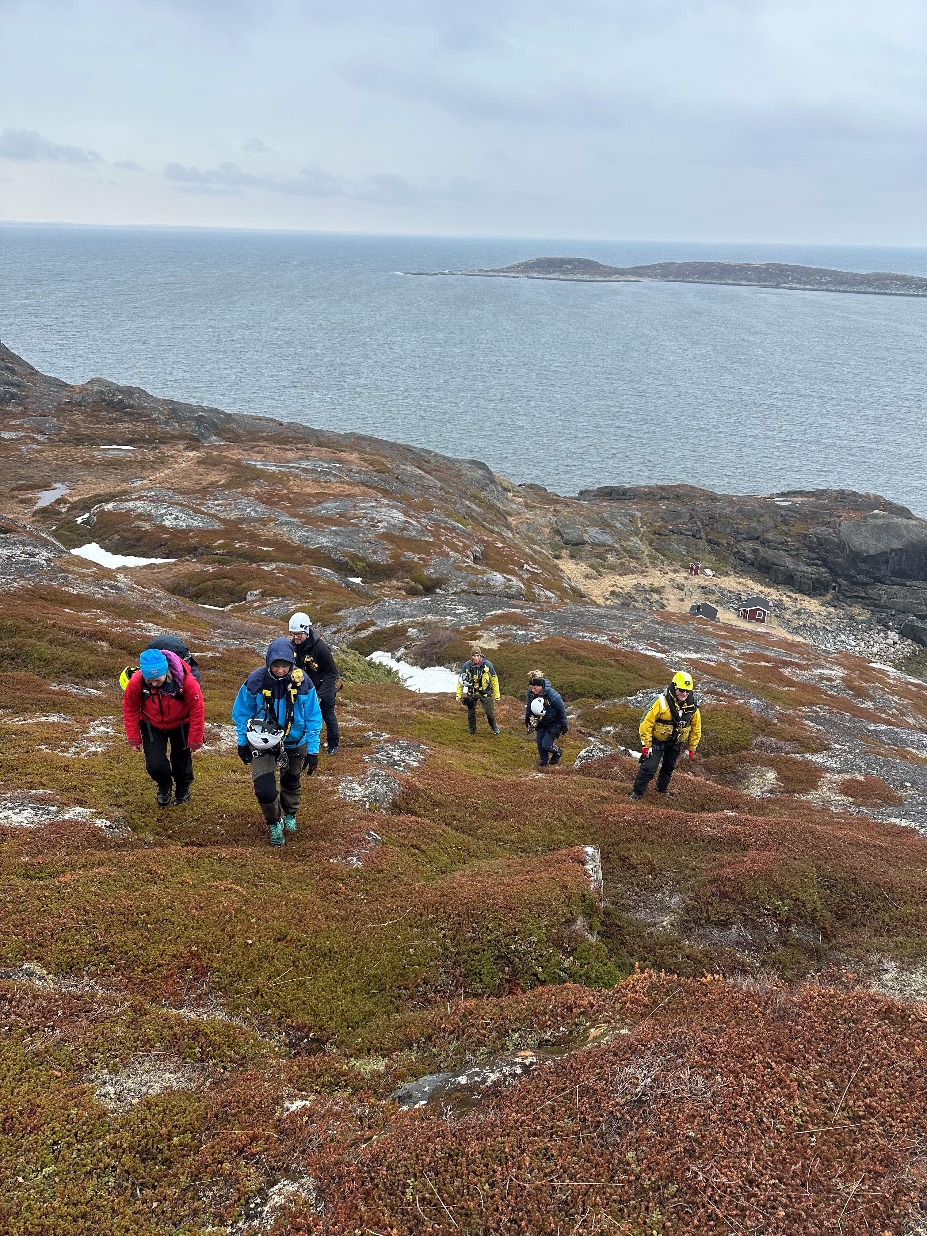 Participants hiking to the Arctic Rappelling Route with panoramic coastal views in Northern Norway.