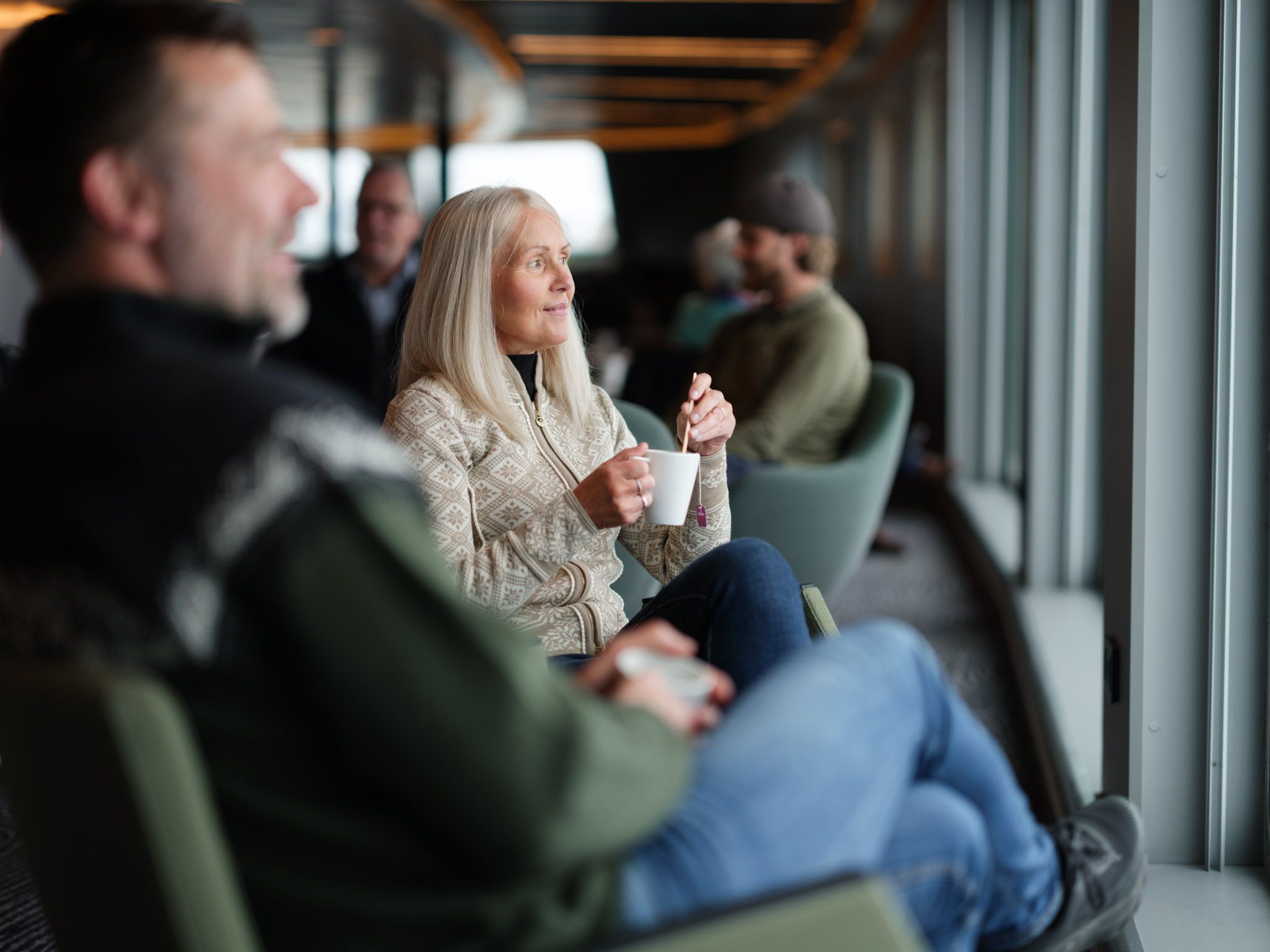gäst som njuter av en kopp kaffe medan hen tittar ut genom fönstret