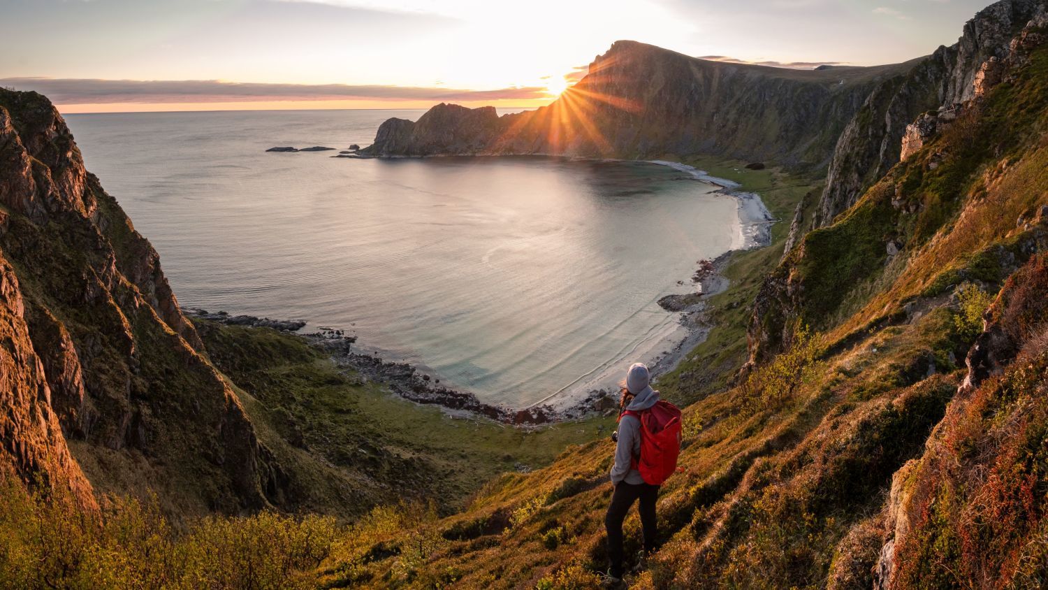 Wanderer, der die Mitternachtssonne auf den Lofoten in Norwegen genießt