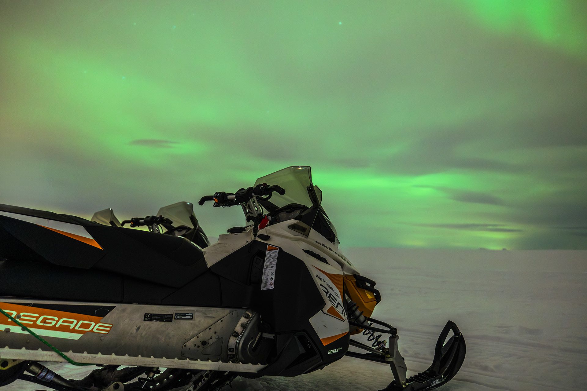Snow mobile in front of northern lights
