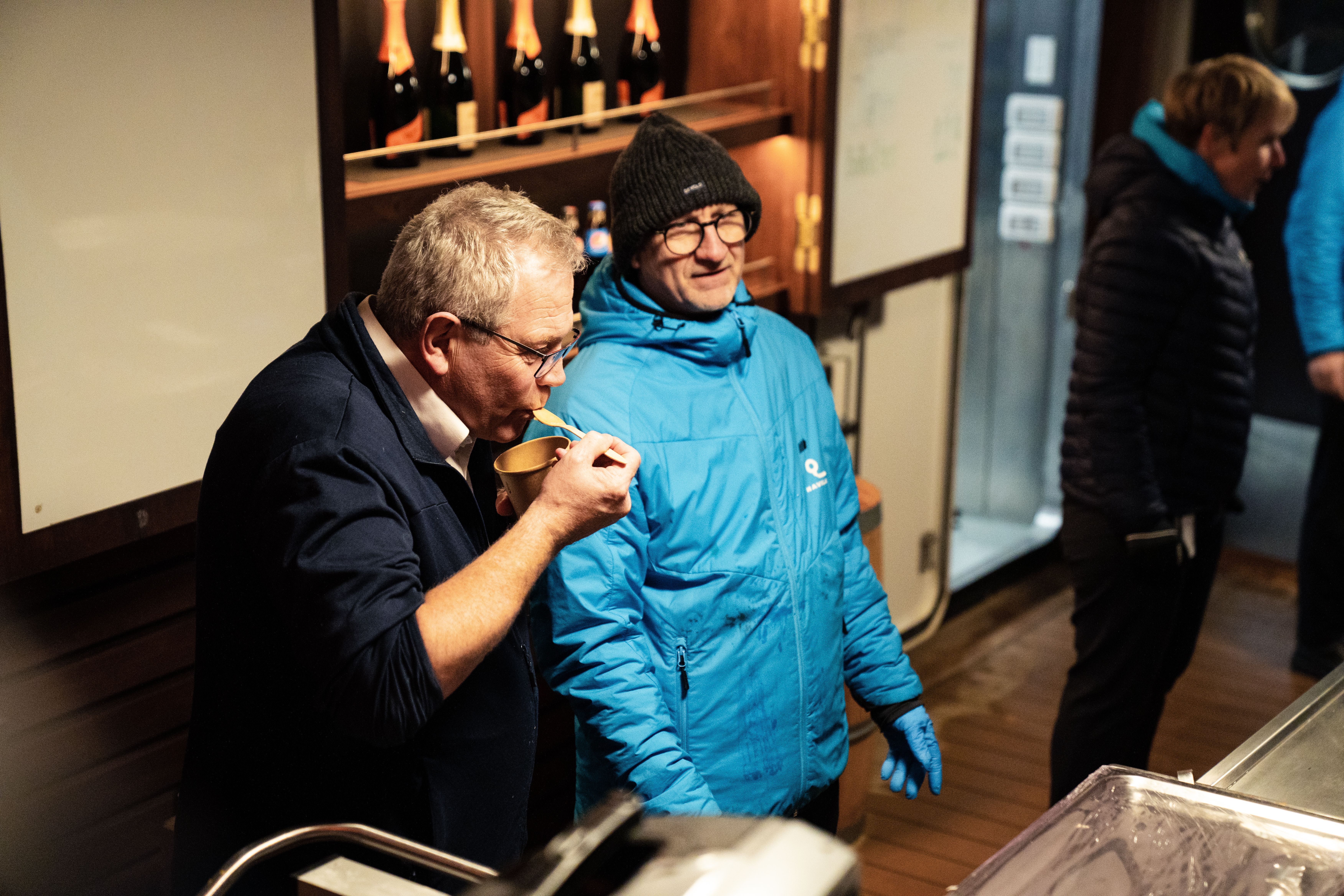 Gäst som smakar på mat serverad av besättningen i utomhusbaren på däck på kvällen