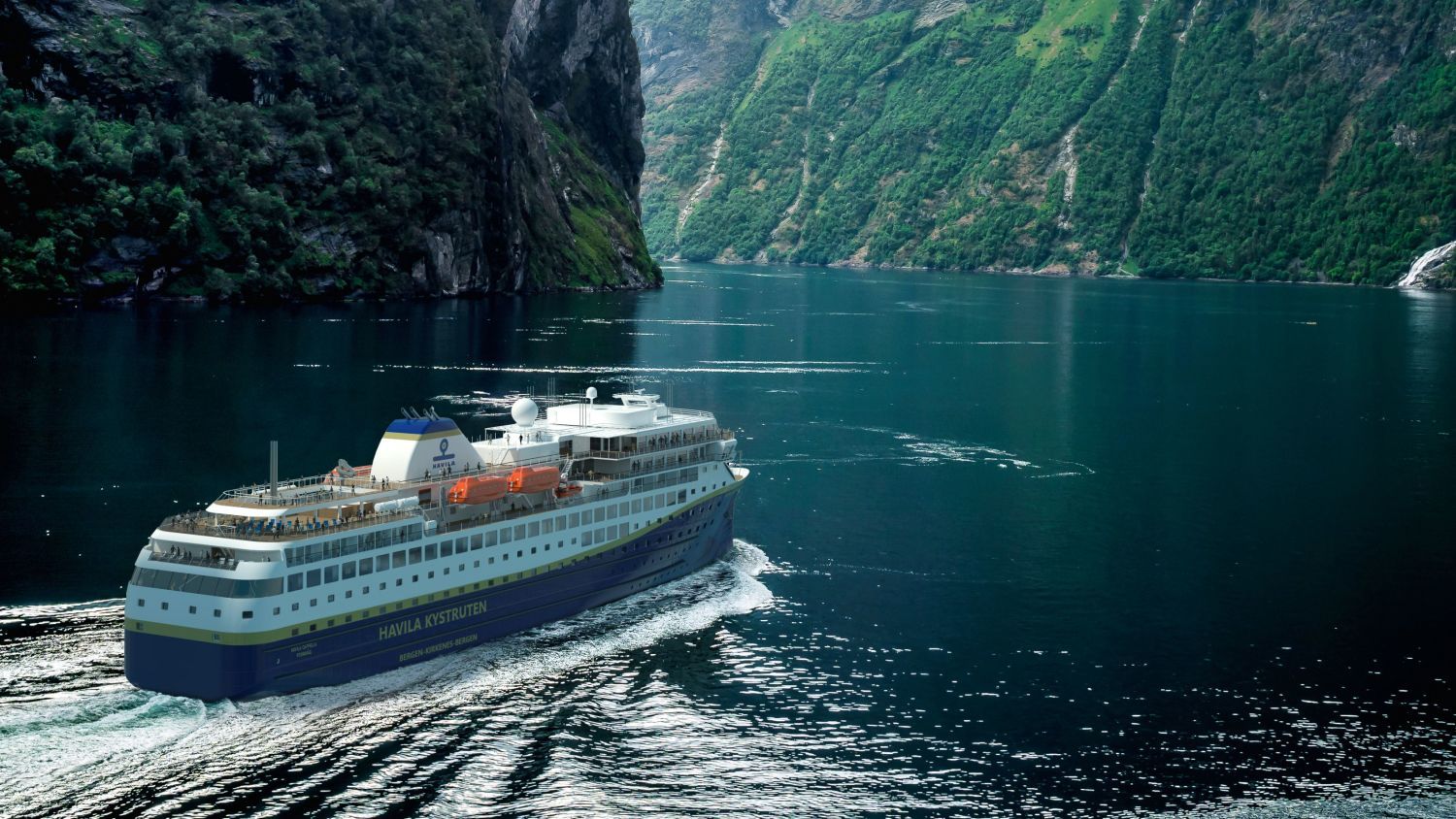 Die Havila Kystruten fährt durch den Storfjord in Westnorwegen, umgeben von steilen Klippen, üppig bewachsenen Berghängen und einer ruhigen Fjordlandschaft.
