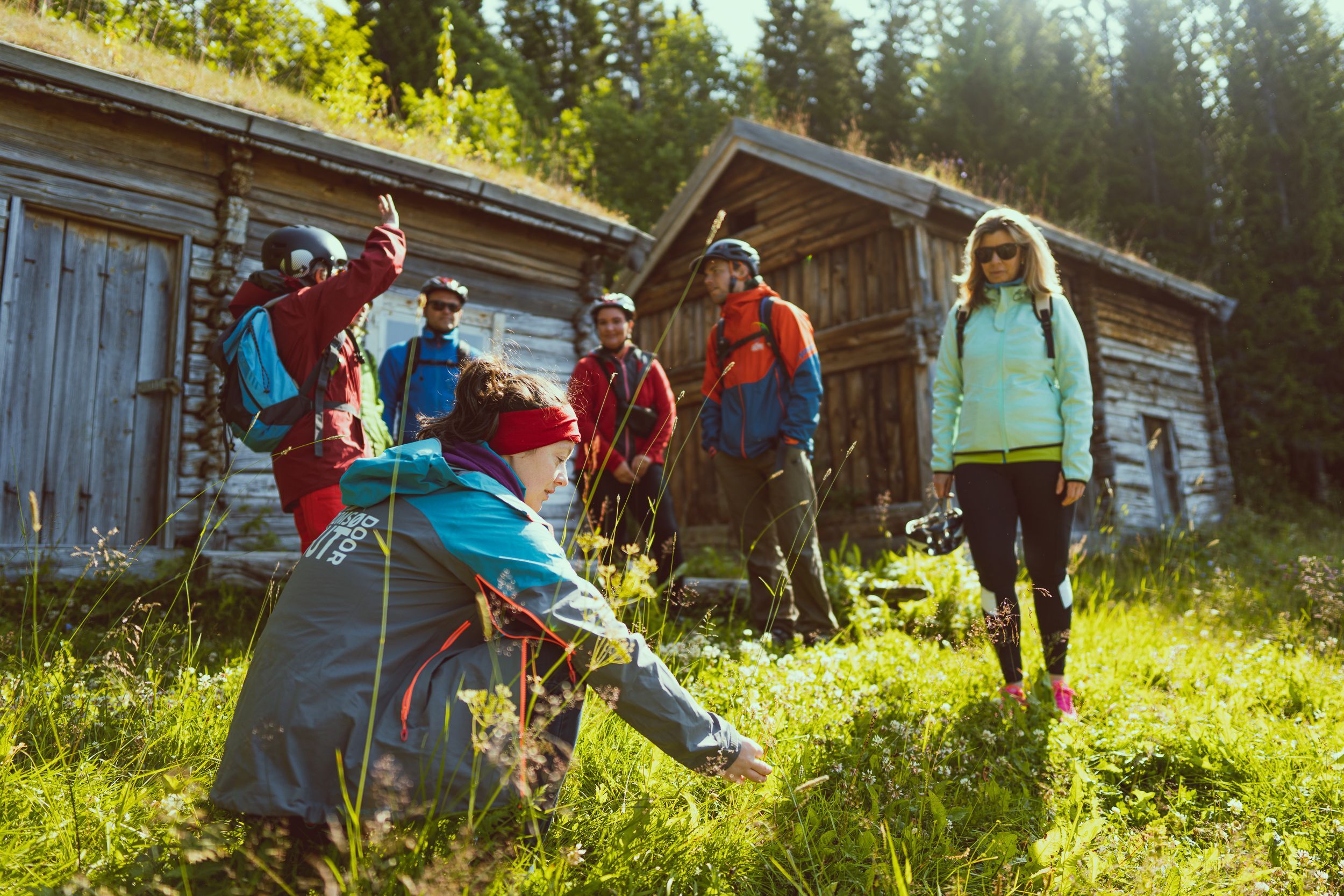 Syklister på en guidet elsykkeltur som besøker tradisjonelle norske gårdshus og lærer om Tromsøs lokale kulturarv.
