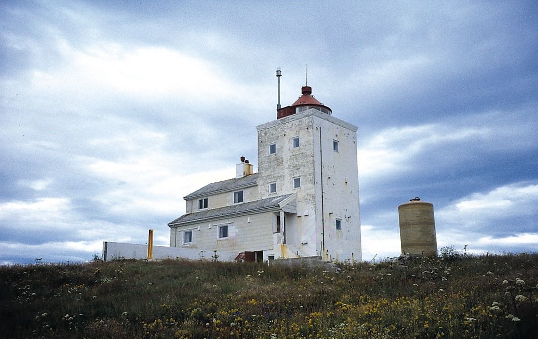 Anda Lighthouse on Anda Island, Norway, overlooking the Norwegian Sea with rugged coastal cliffs, rocky islets, and dramatic Arctic scenery