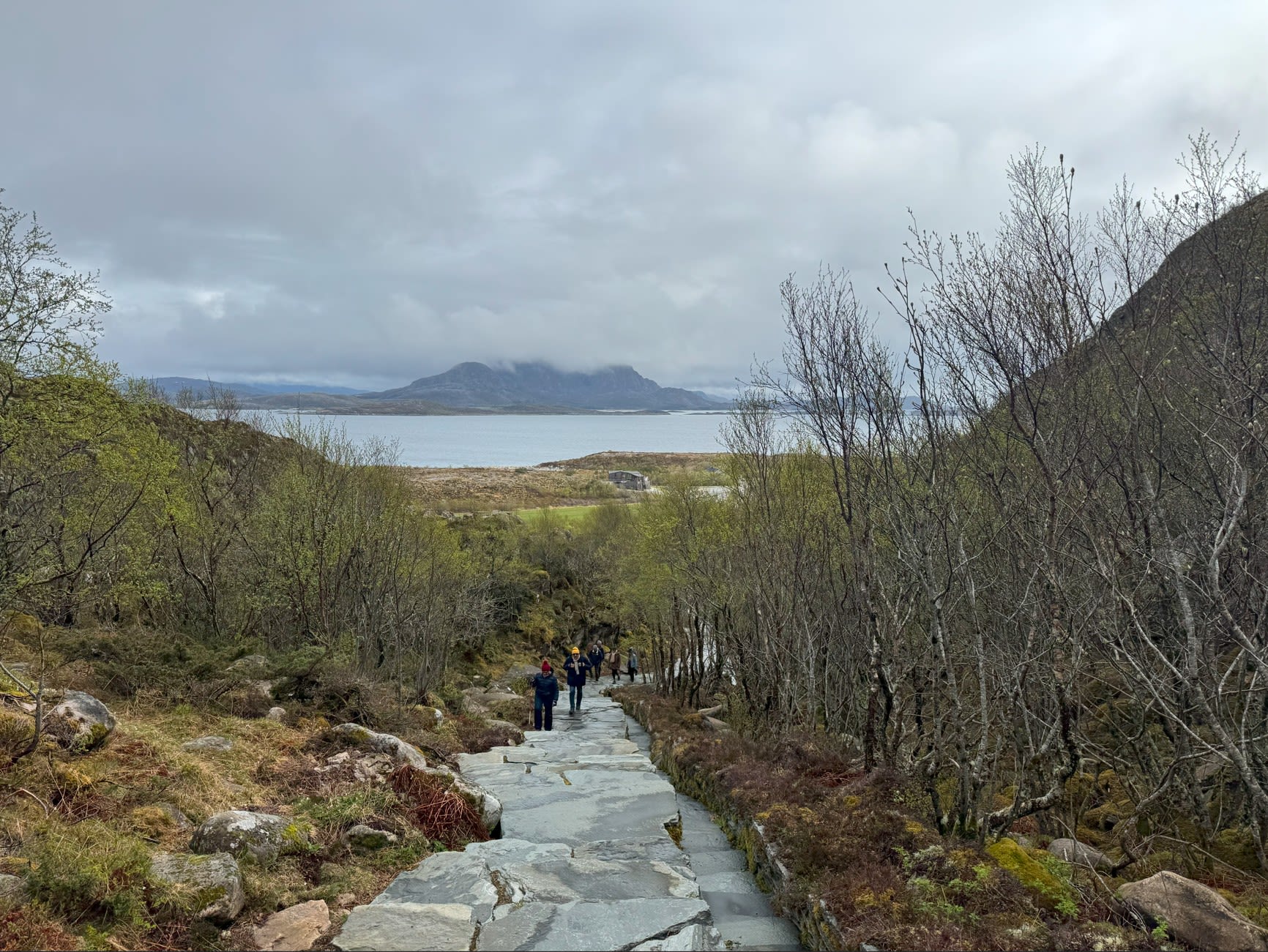 Utfluktsgjester som går opp sherpatrappene mot Torghatten-fjellet