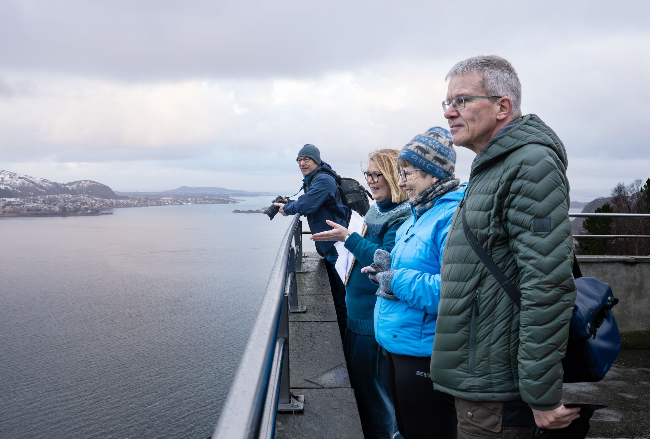 Gjester beundrer den fantastiske panoramautsikten over Ålesunds jugendarkitektur, de omkringliggende øyene og fjordene fra det ikoniske utsiktspunktet på Aksla under en guidet fottur.