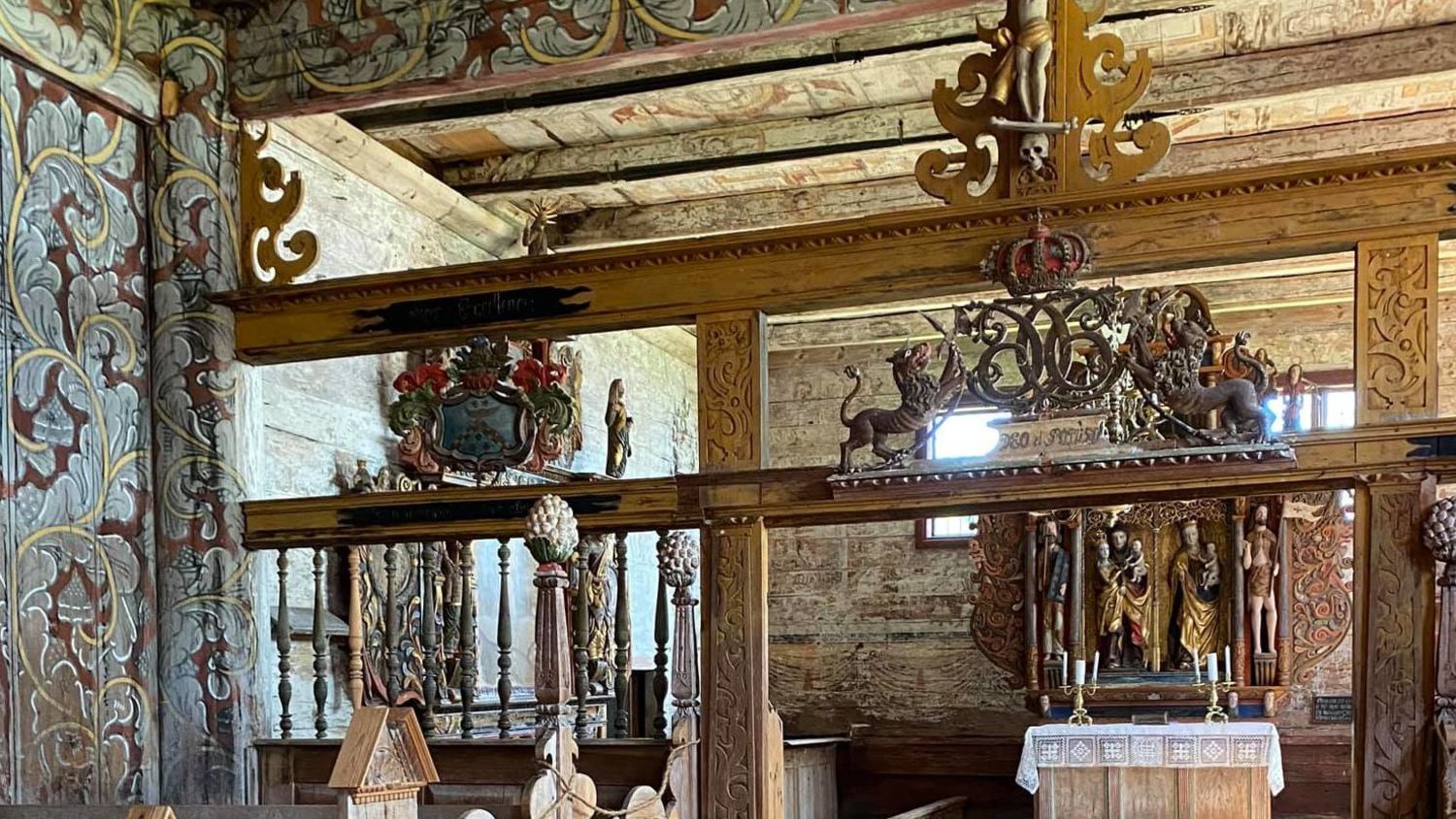 Aufwendig gestaltetes hölzernes Innenraum des Stabkirche Borgund in Norwegen mit handbemalten Verzierungen, geschnitzten Balken, mittelalterlichem Altar und jahrhundertealter Handwerkskunst