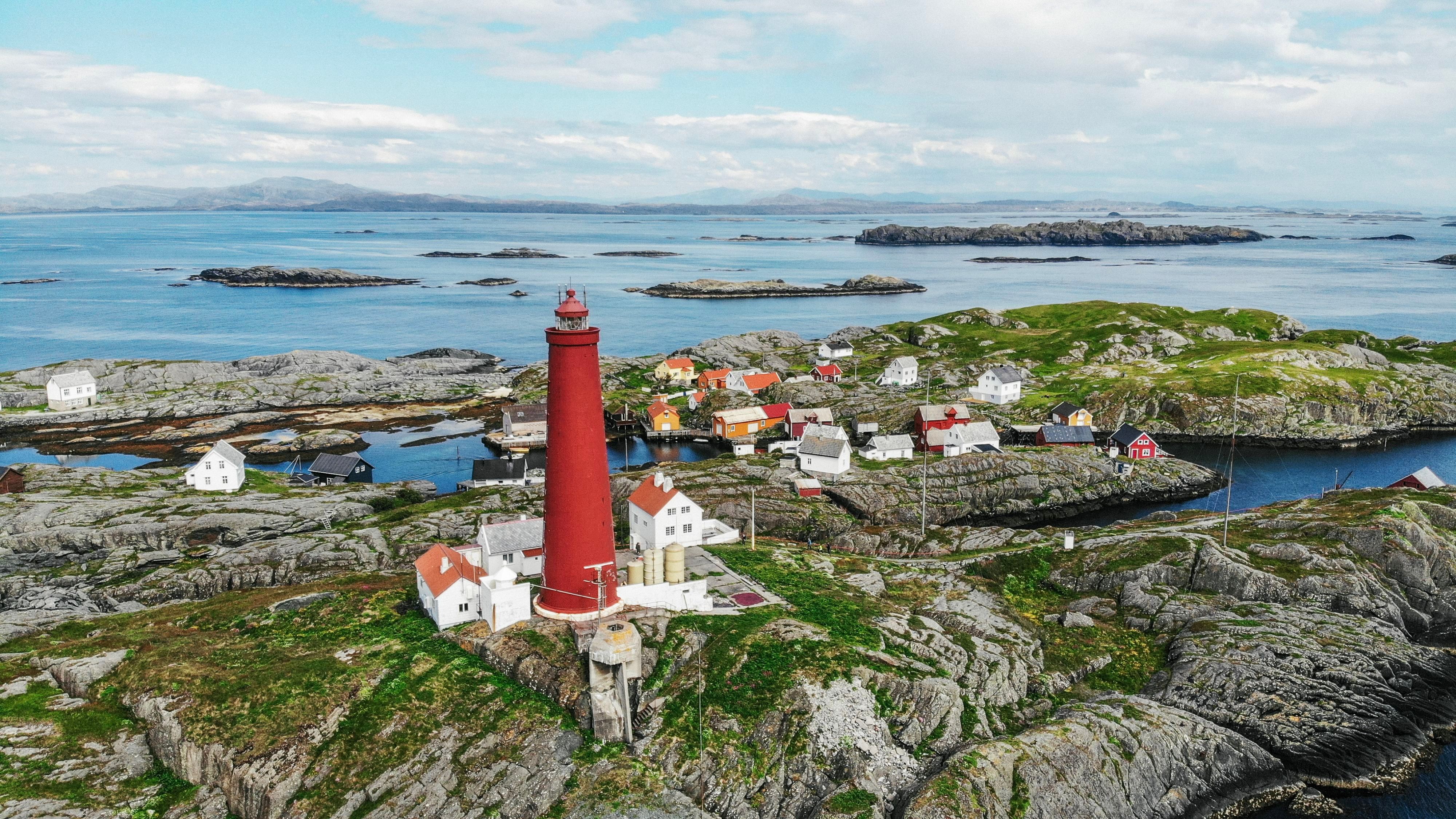 Historic Utvær Lighthouse in Sogn og Fjordane, Norway, surrounded by rugged skerries, traditional island homes, and stunning coastal scenery
