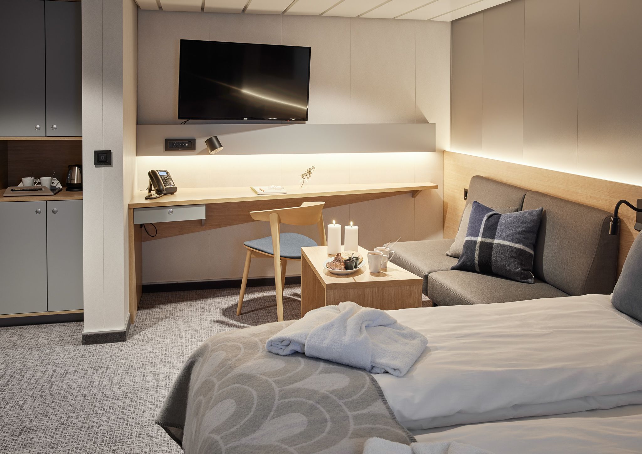 Barrierefreie Superior-Kabine mit Meerblick, großzügigem Sitzbereich, Schreibtisch, TV, Kaffeestation und rollstuhlgerechtem Grundriss.