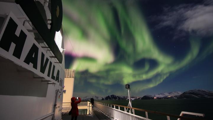 Nordlichter, gesehen von einem Havila-Voyages-Schiff, das entlang der norwegischen Küste segelt.