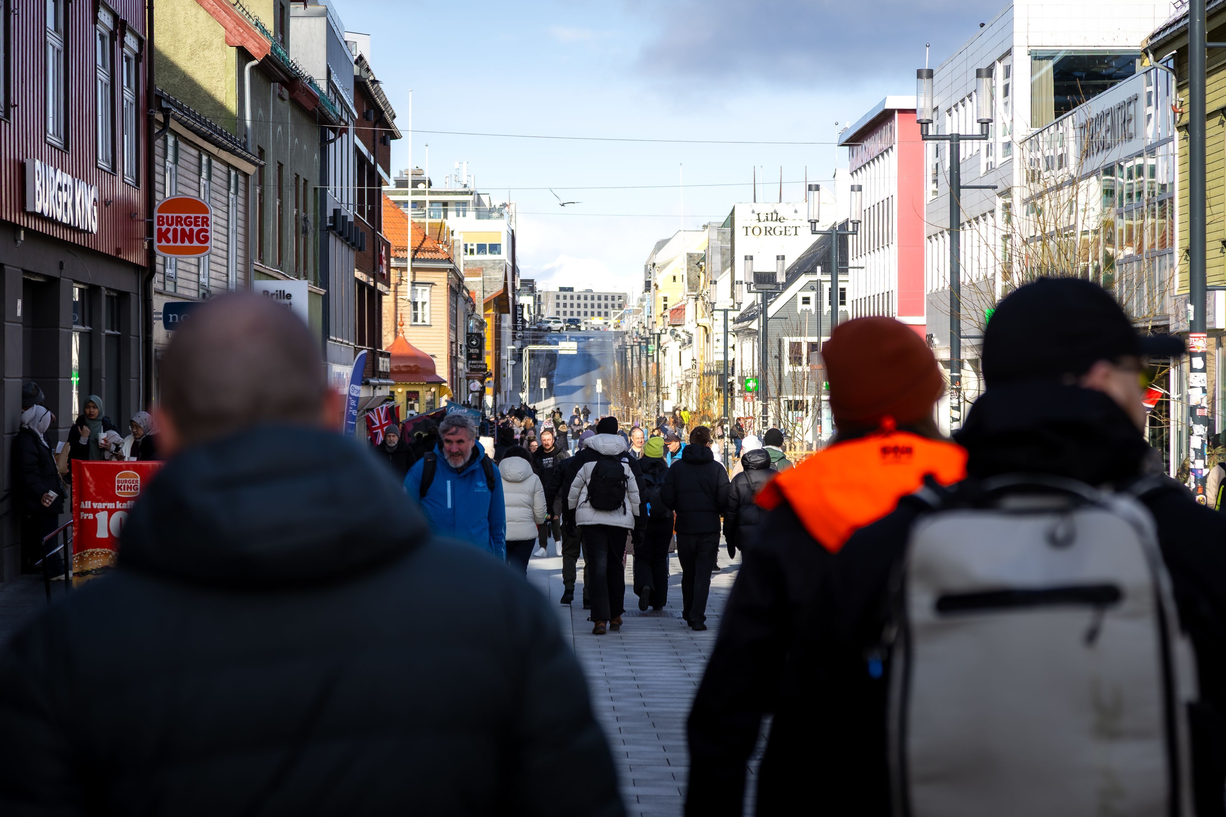 Guests exploring Storgata, Tromsø’s lively main shopping street, during a guided city walk through the heart of the Arctic city.