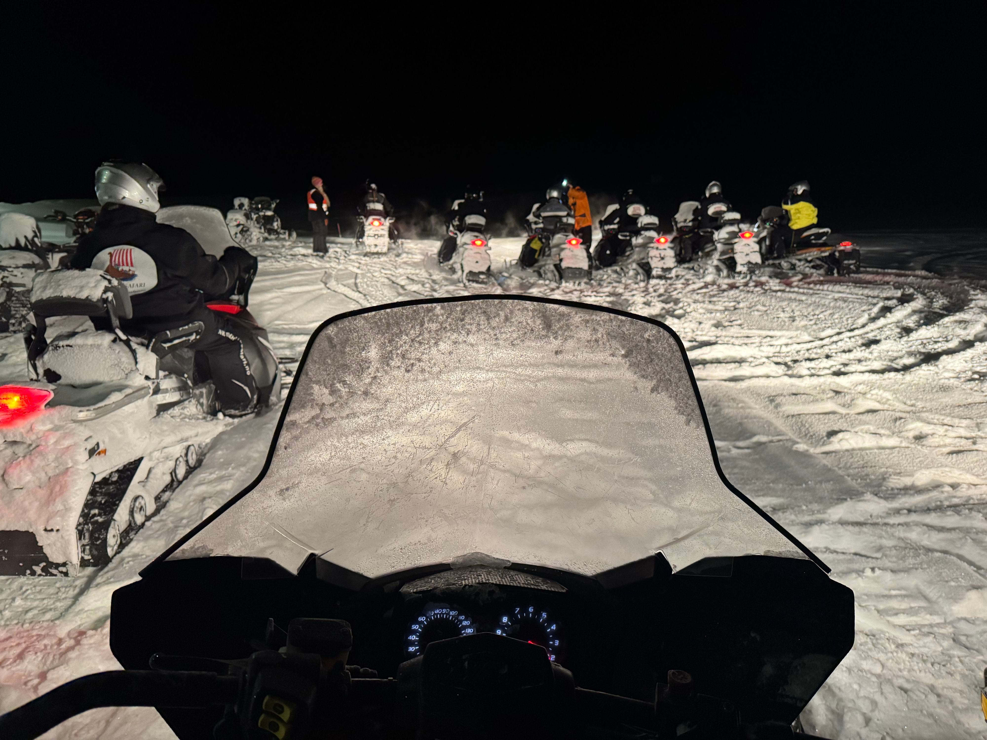 Group of snowmobiles preparing for a night polar tour from Kjøllefjord.