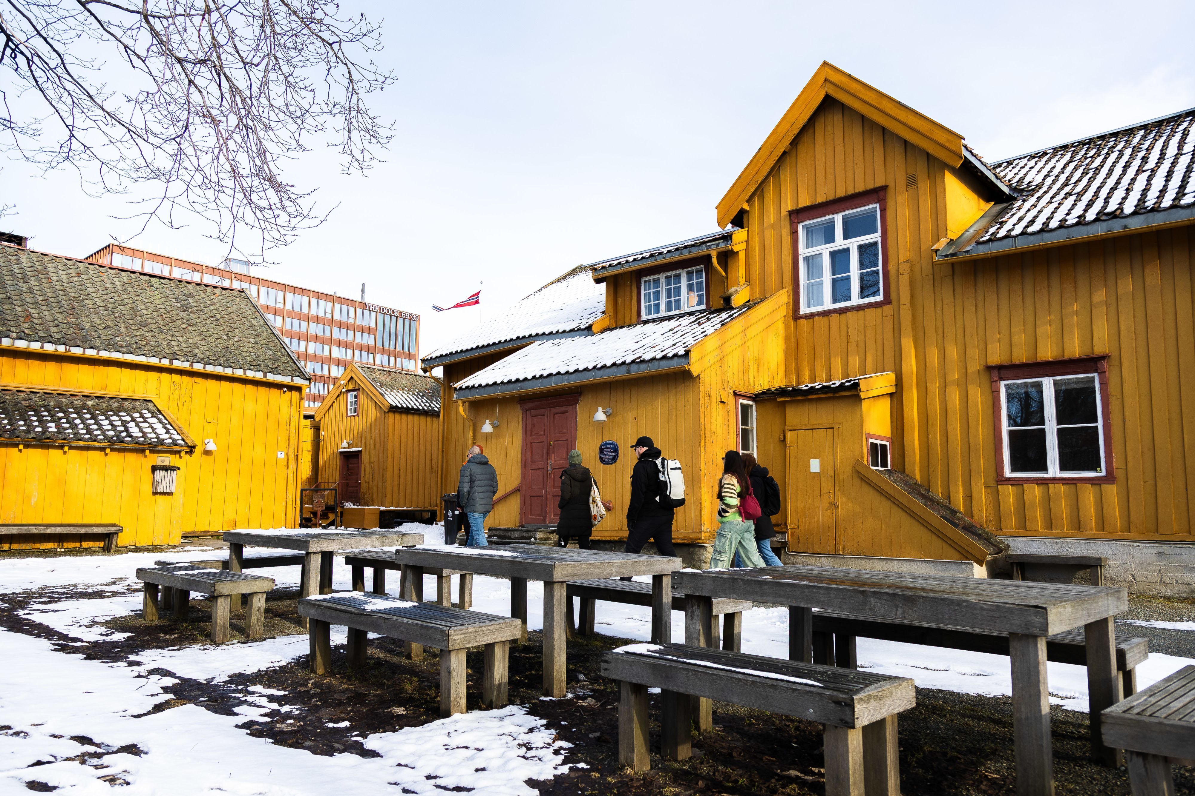 Guests exploring Tromsø’s historic wooden buildings on a guided city walk through the charming old town in Northern Norway.