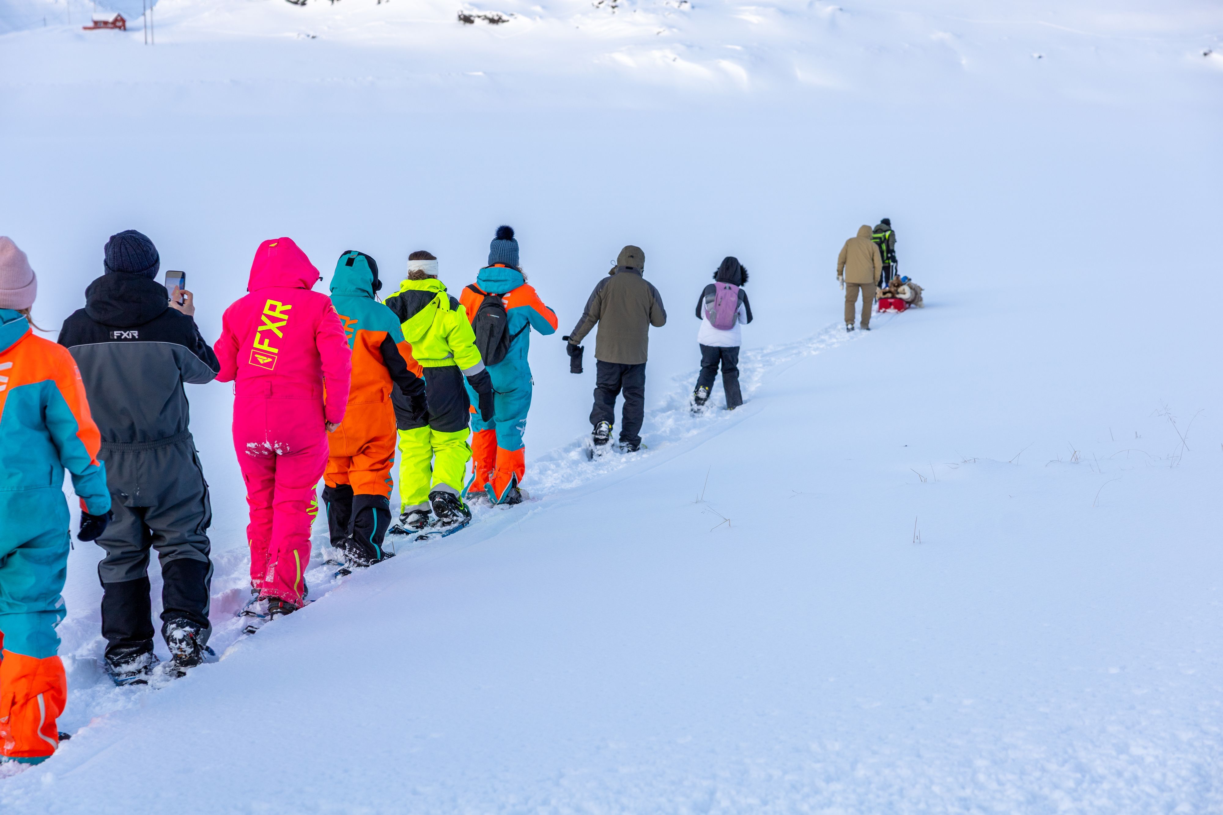 Group snowshoeing across the Arctic landscape to an ice fishing spot near Honningsvåg.