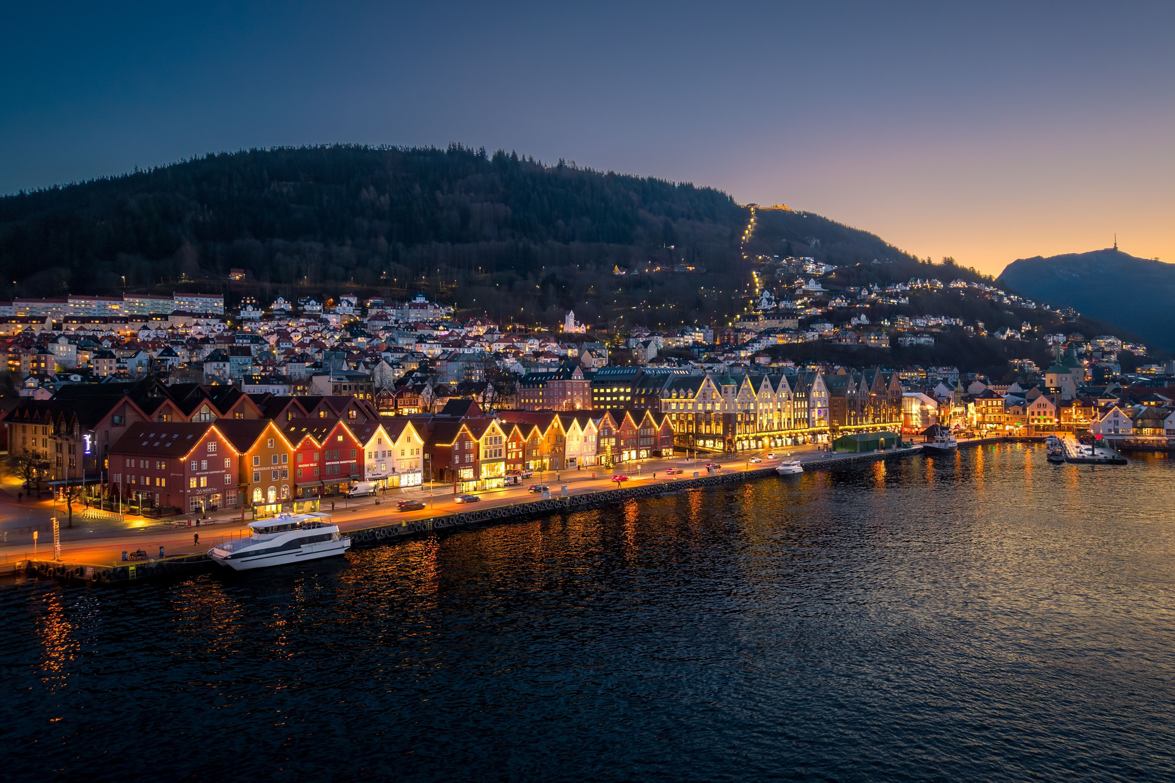 Flyfoto om natten av den historiske byen Bergen i Norge, med fargerike trehus ved havnen 