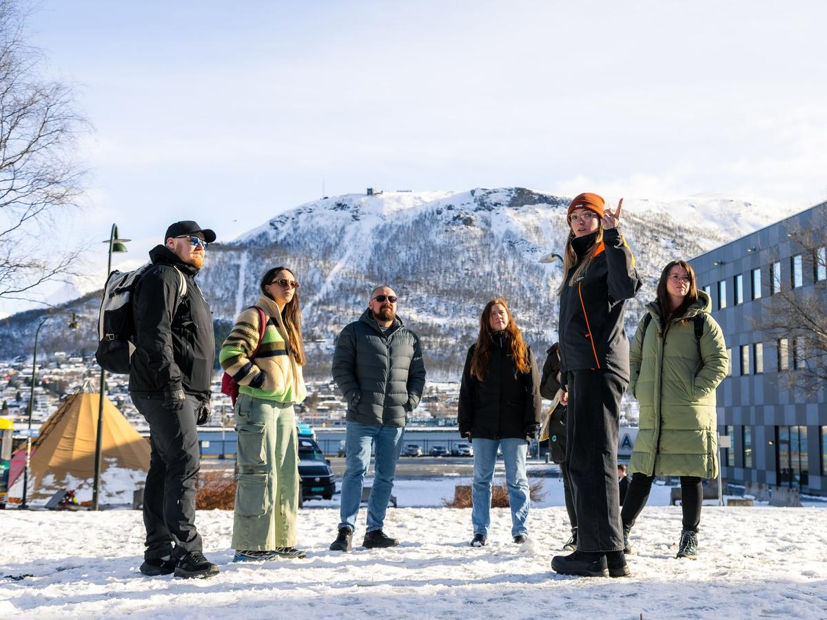 Gäster poserar med den berömda trollstatyn under en guidad stadsrundtur i Tromsø, där de upptäcker lokal folklore och ikoniska landmärken i den arktiska staden.
