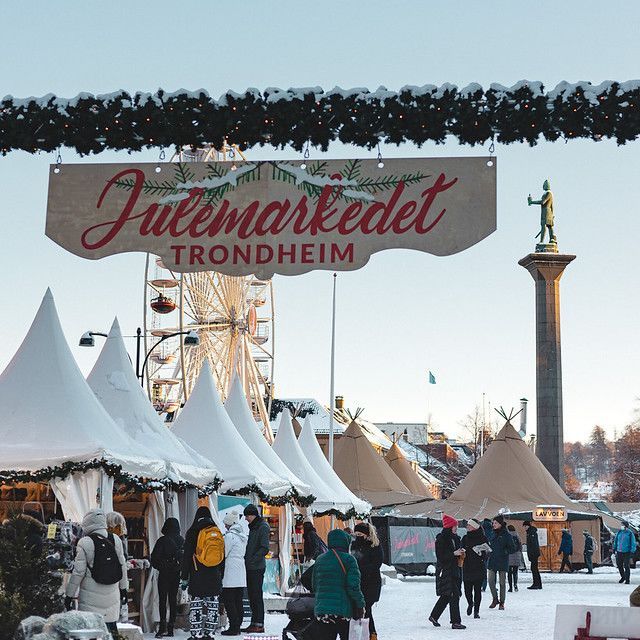 Besøkende utforsker det festlige julemarkedet i Trondheim, med pyntede boder og sesongbaserte attraksjoner.