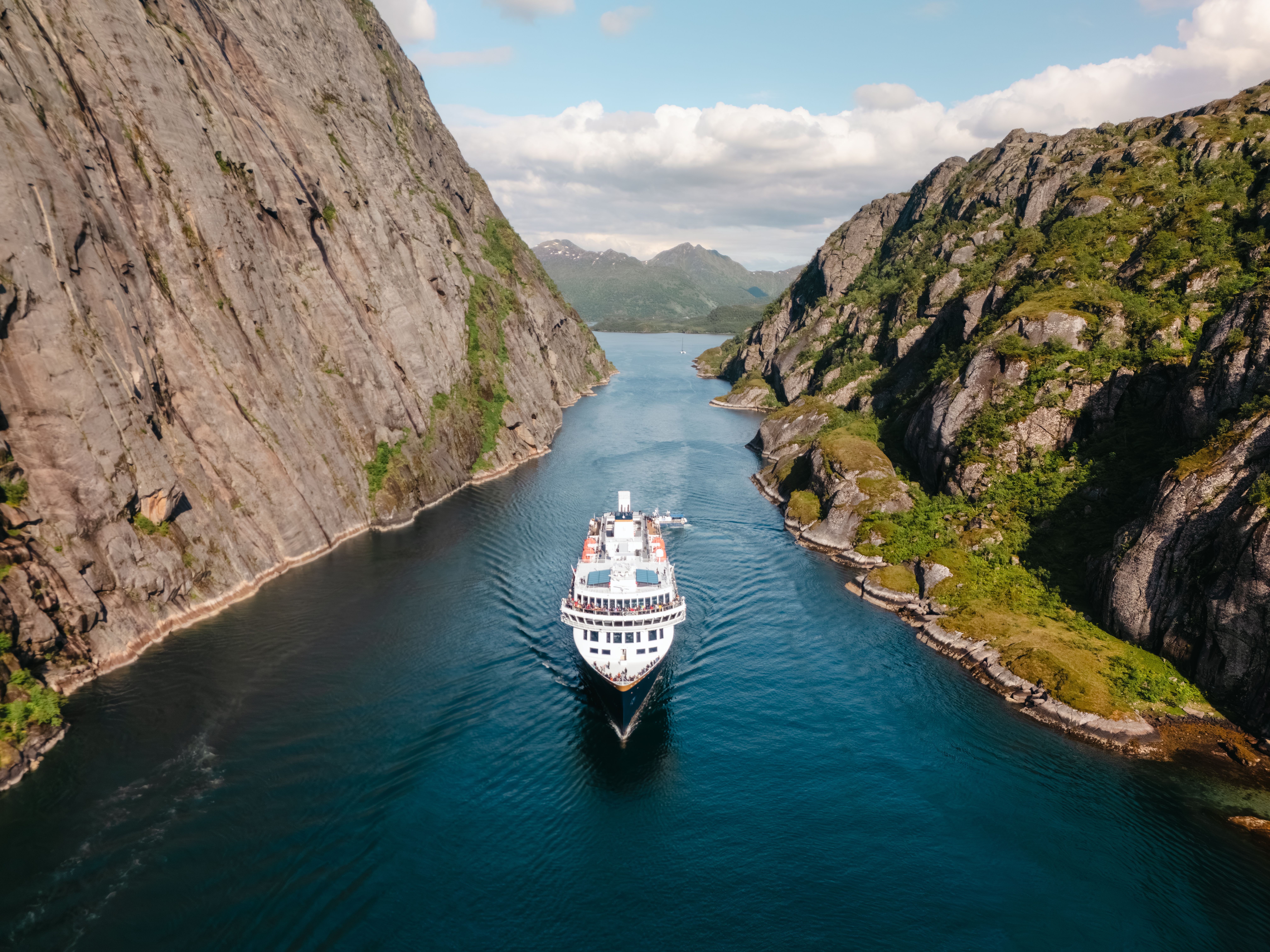 Luftfoto av et Havila-skip som seiler inn i Trollfjorden i Nord-Norge
