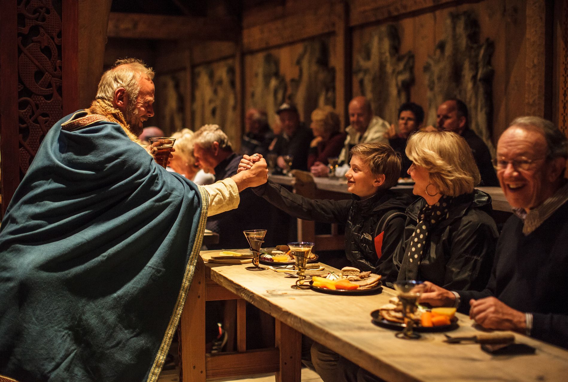 Skuespillere under høvdinggildet i vikingtiden på Lofotr Vikingmuseum i Norge