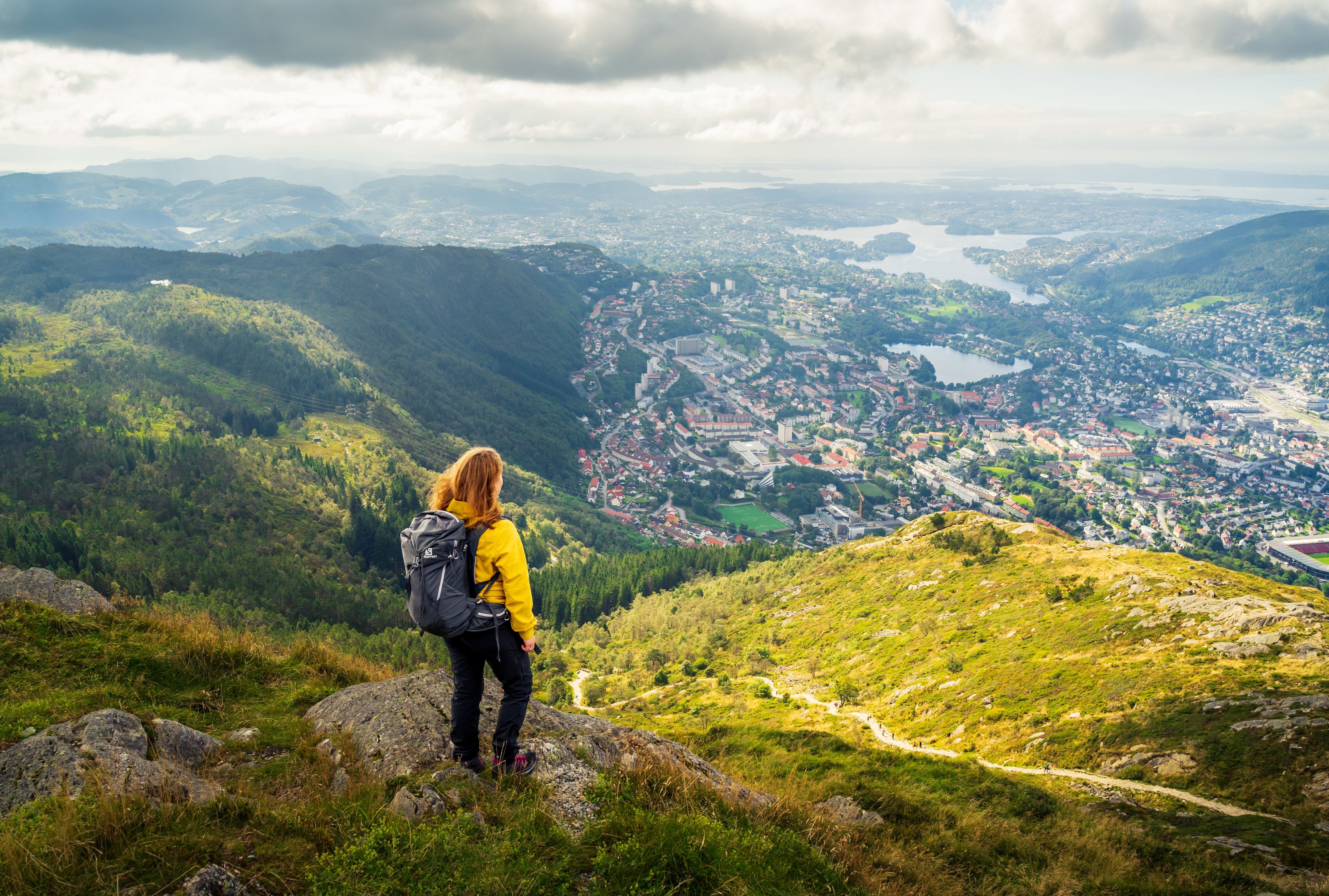 Wanderer genießt den Panoramablick vom Berg Ulriken über Bergen und die umliegenden Fjorde.