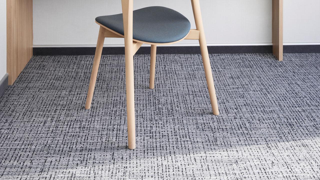 Arbeitsbereich in der Panoramic Corner Mini Suite mit großzügigem Schreibtisch, Stuhl, Telefon, Steckdosen und natürlichem Licht durch das Panoramafenster der Suite.