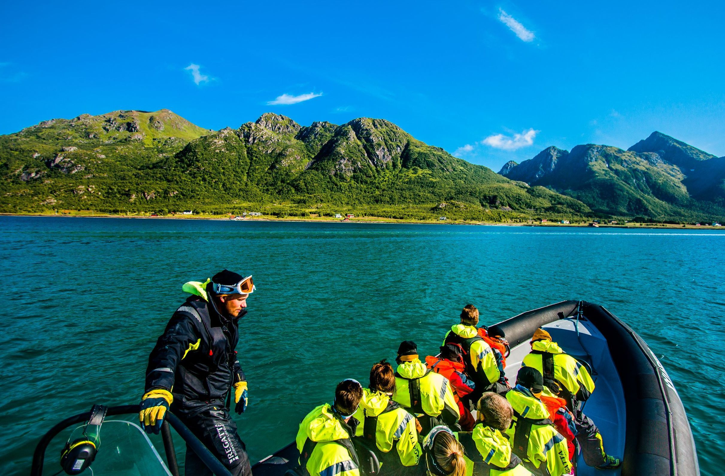 Group of people in a rib boat with a mountain backdrop