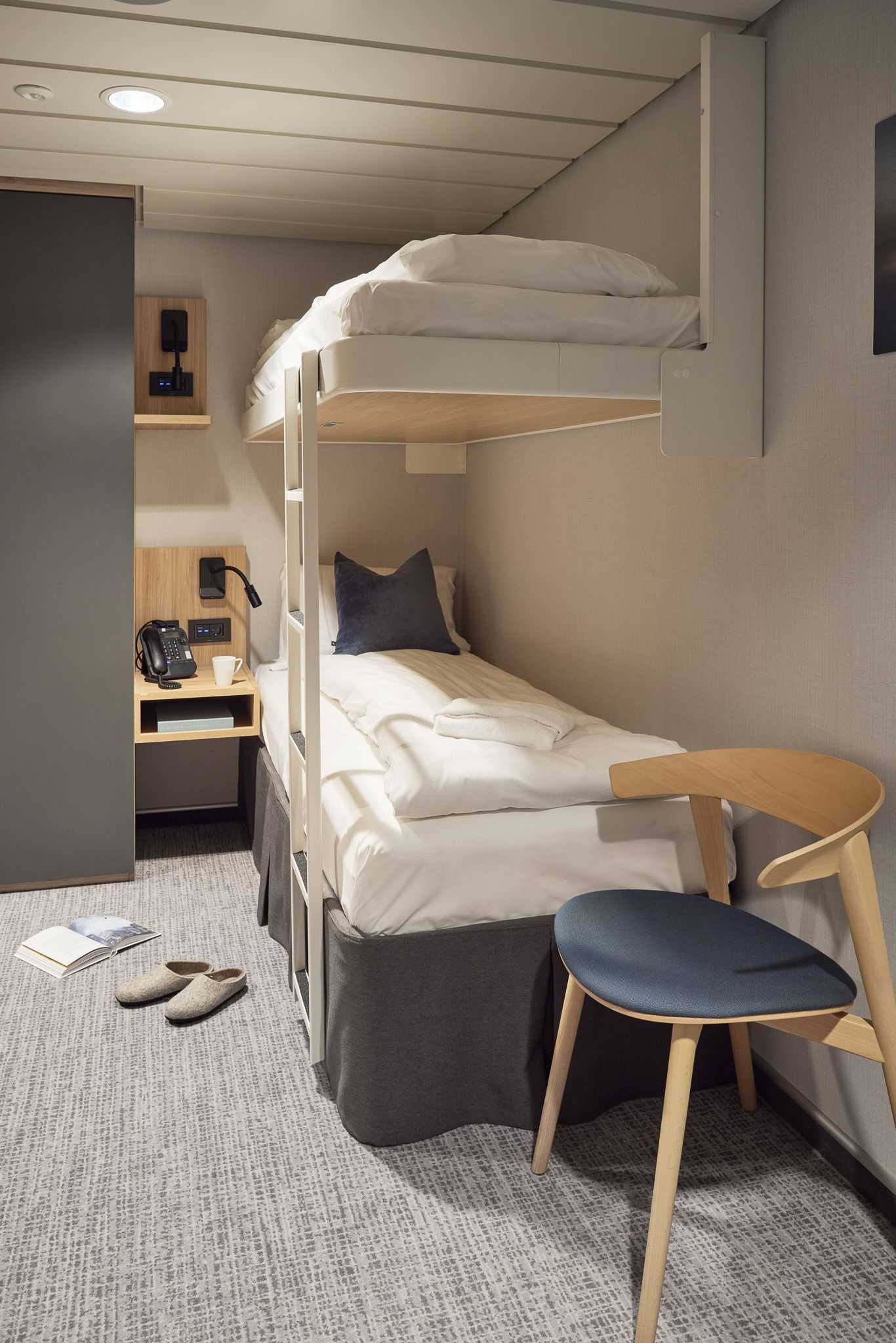 Barrierefreie Innenkabine auf einem Kreuzfahrtschiff mit Etagenbetten, Stauraum am Bett, Sitzecke und modernem, platzsparendem Design.